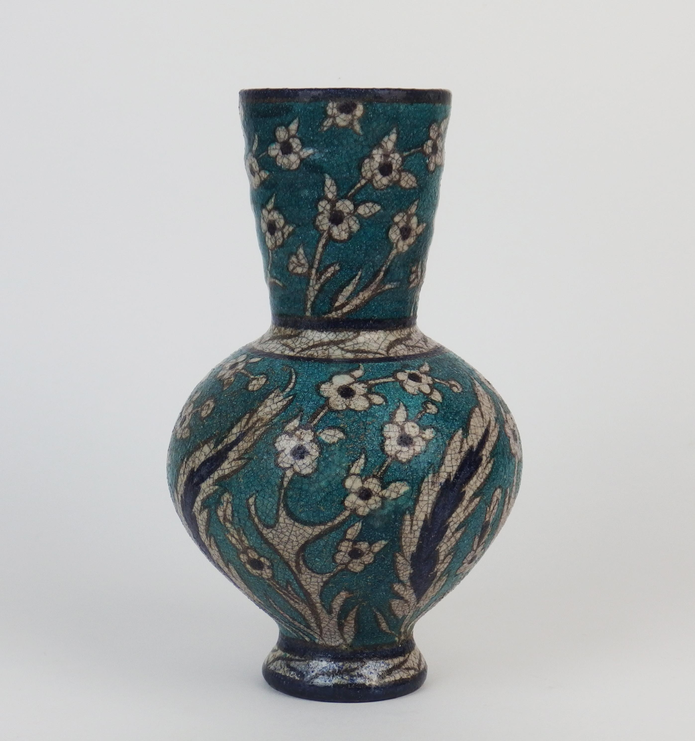 An iznik style glazed earthenware vase with blue ,turquoise and white patterns .Signed Lachenal.
Edmond Lachenal(1855-1948)created his workshop in 1881 after working in Theodore Deck workshop.He awarded a gilt medal in the 1889 Paris 