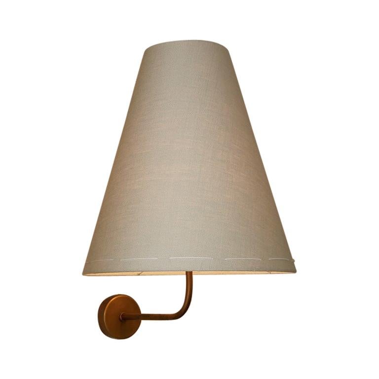 Queste applique in ottone e lino italiano di grandi dimensioni, semplici e fatte a mano, con paralumi in lino cuciti a mano, illuminano con livelli di luce simili a lampade da tavolo di grandi dimensioni. Gettano una luce intima e accogliente senza