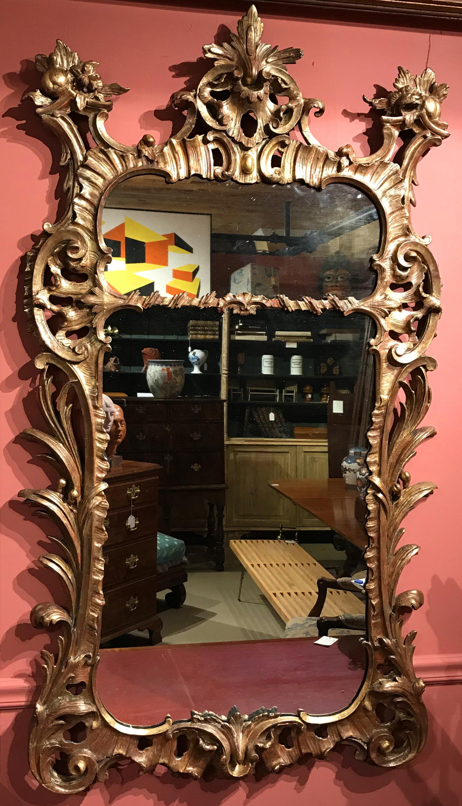 An exceptional polychrome giltwood English Rococo mirror, with a fine pierce-carved scrollwork surround, dating to the 18th century in very good to excellent overall condition, with minor imperfections, losses, and light expected wear from age and