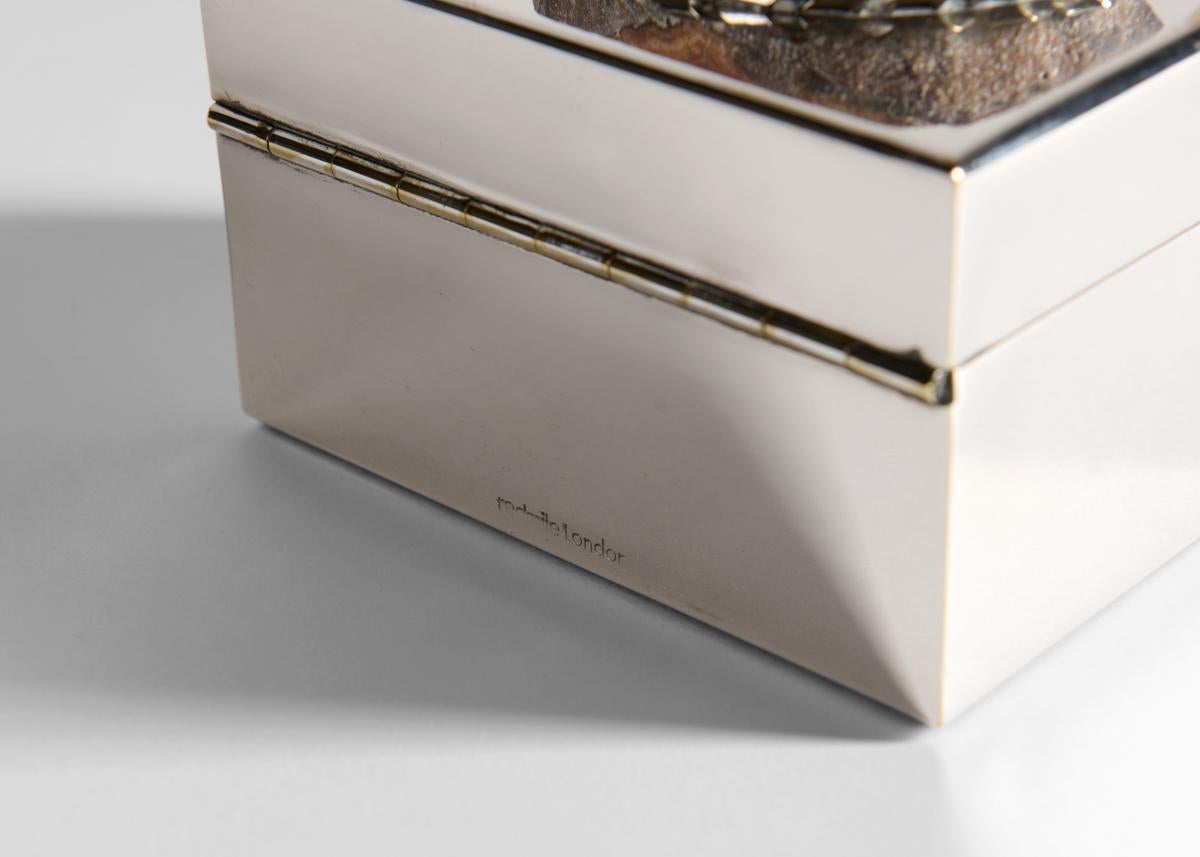 Signed.

This box clad in silver plate and adorned with a cedar and agate, is typical of Redmile whose works combined an appreciation for antique sophistication with an unusual flair.