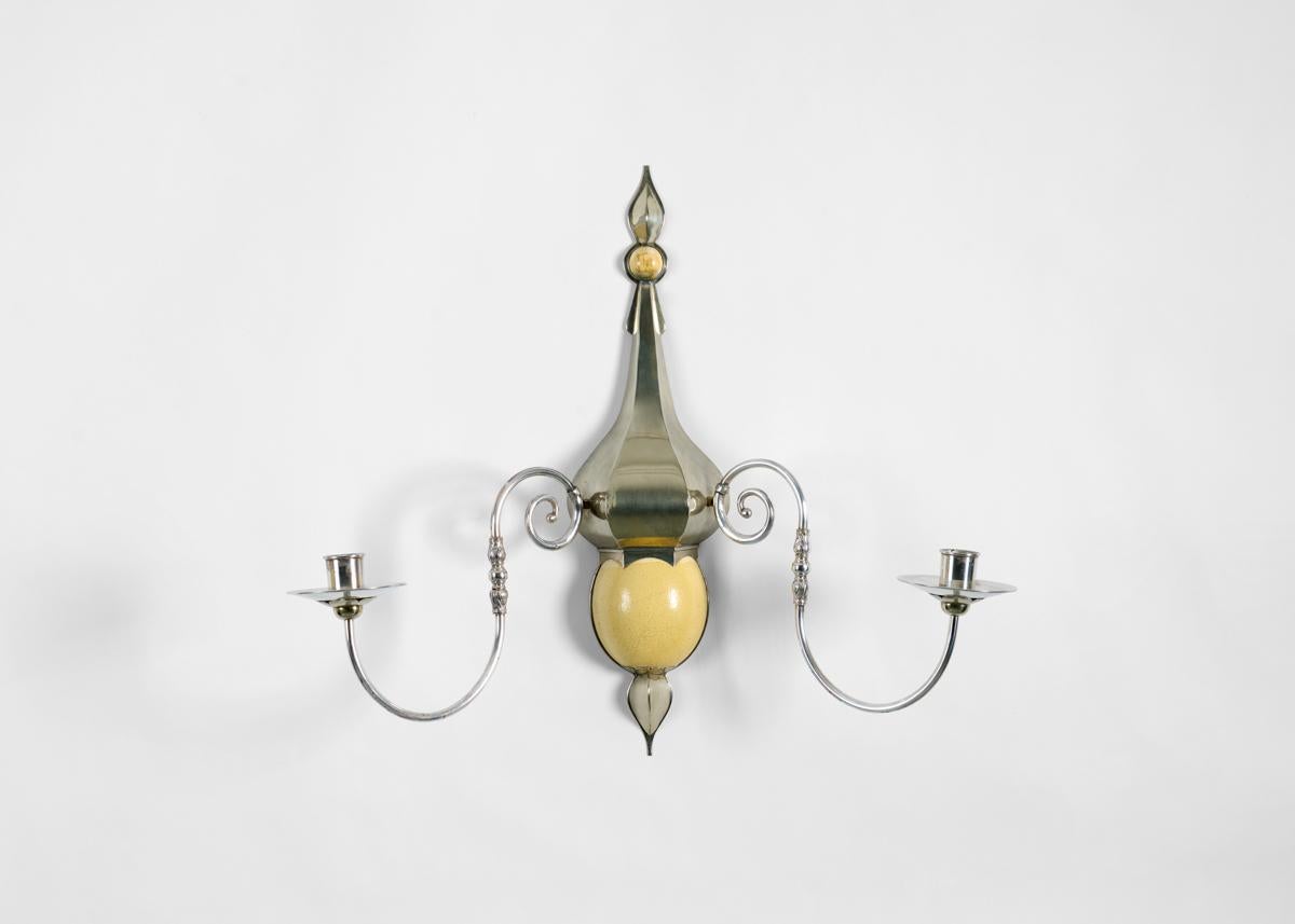 This sconce, with its ostrich egg ornaments, and delicate, symmetrical arms, is typical of Redmile whose works combined an appreciation for antique sophistication with an unusual flair.

Marked 