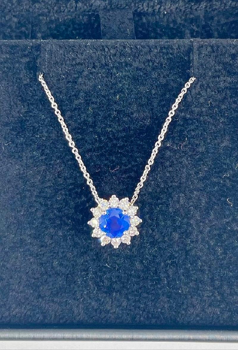 This sweet pendant by J. Birnbach features a gorgeous 1.07 carat round blue sapphire in a velvety cornflower blue. The center gemstone is framed by a halo of round diamonds which total 0.40 carats. The pendant is stationary on the chain, which