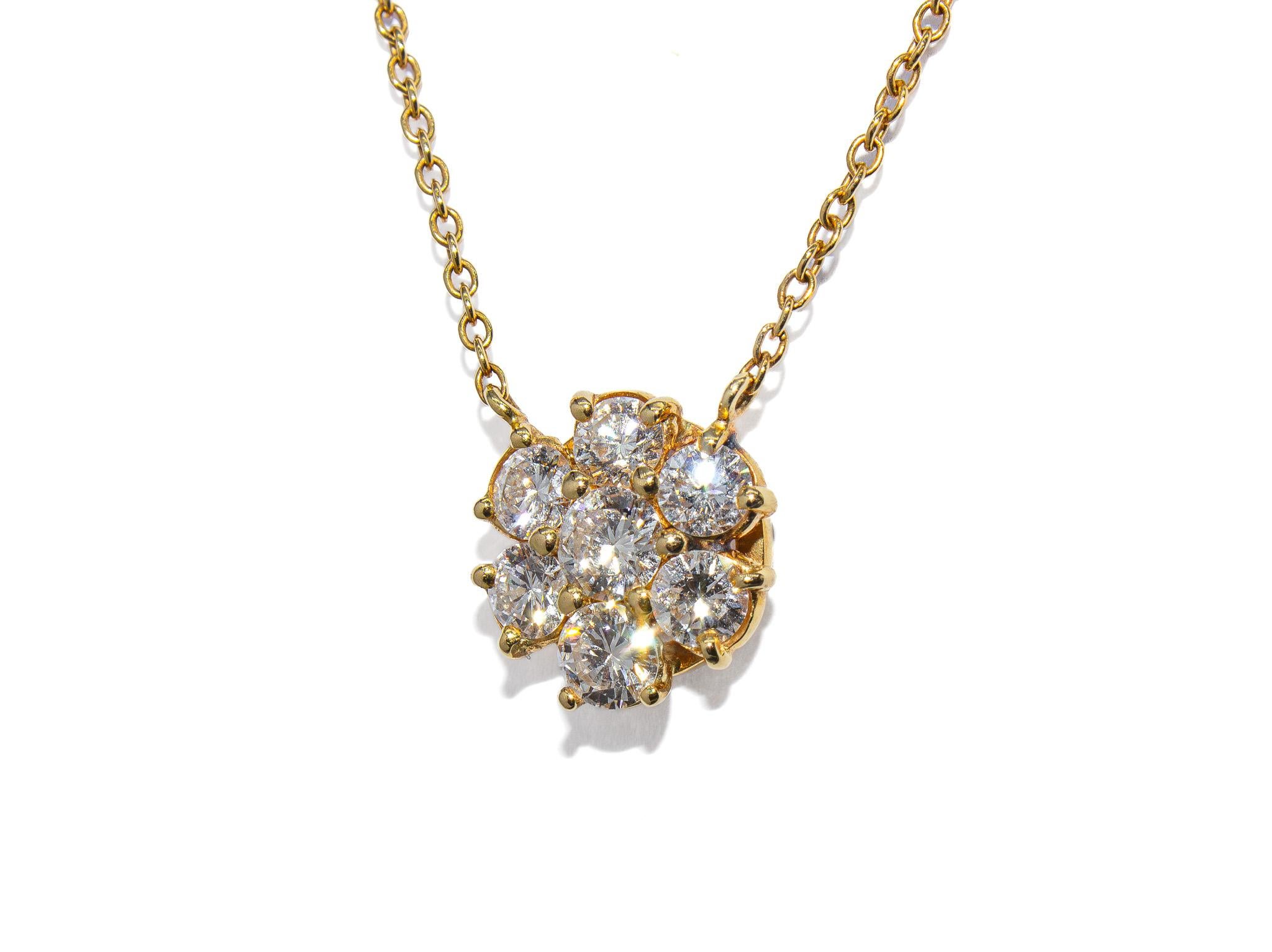 Realizzata in oro giallo 18 carati, questa affascinante collana pendente presenta un delicato motivo floreale con sette diamanti tondi brillanti per un totale di circa 1,20 carati di colore G - H e purezza SI. I diamanti sono disposti in modo da