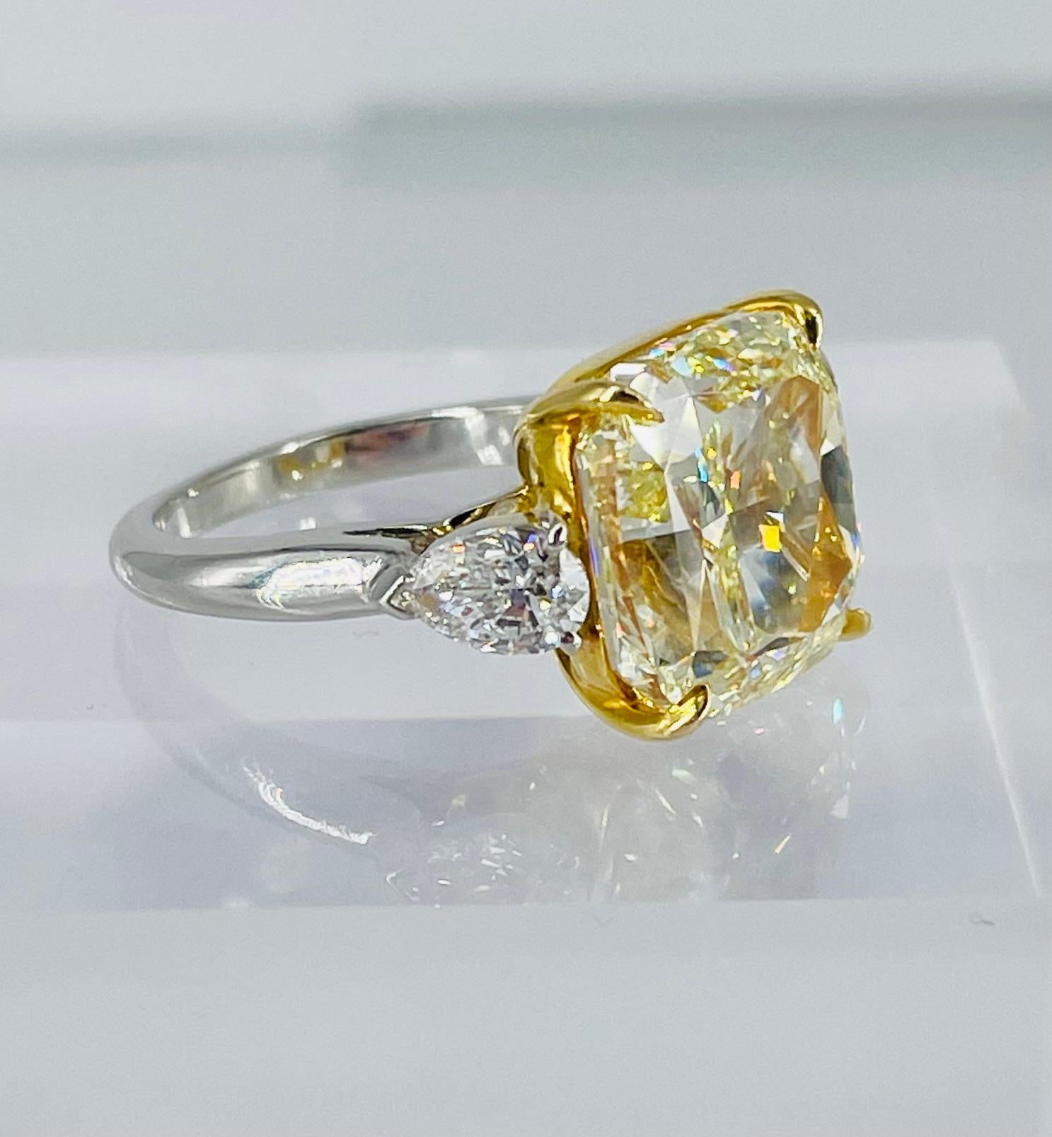 This gorgeous piece of sunshine is a showstopper! This GIA certified 13.05 carat Fancy Yellow cushion shape diamond is a vibrant yellow with brilliant sparkle. The center diamond is set in 18K yellow gold so the prongs will disappear against the