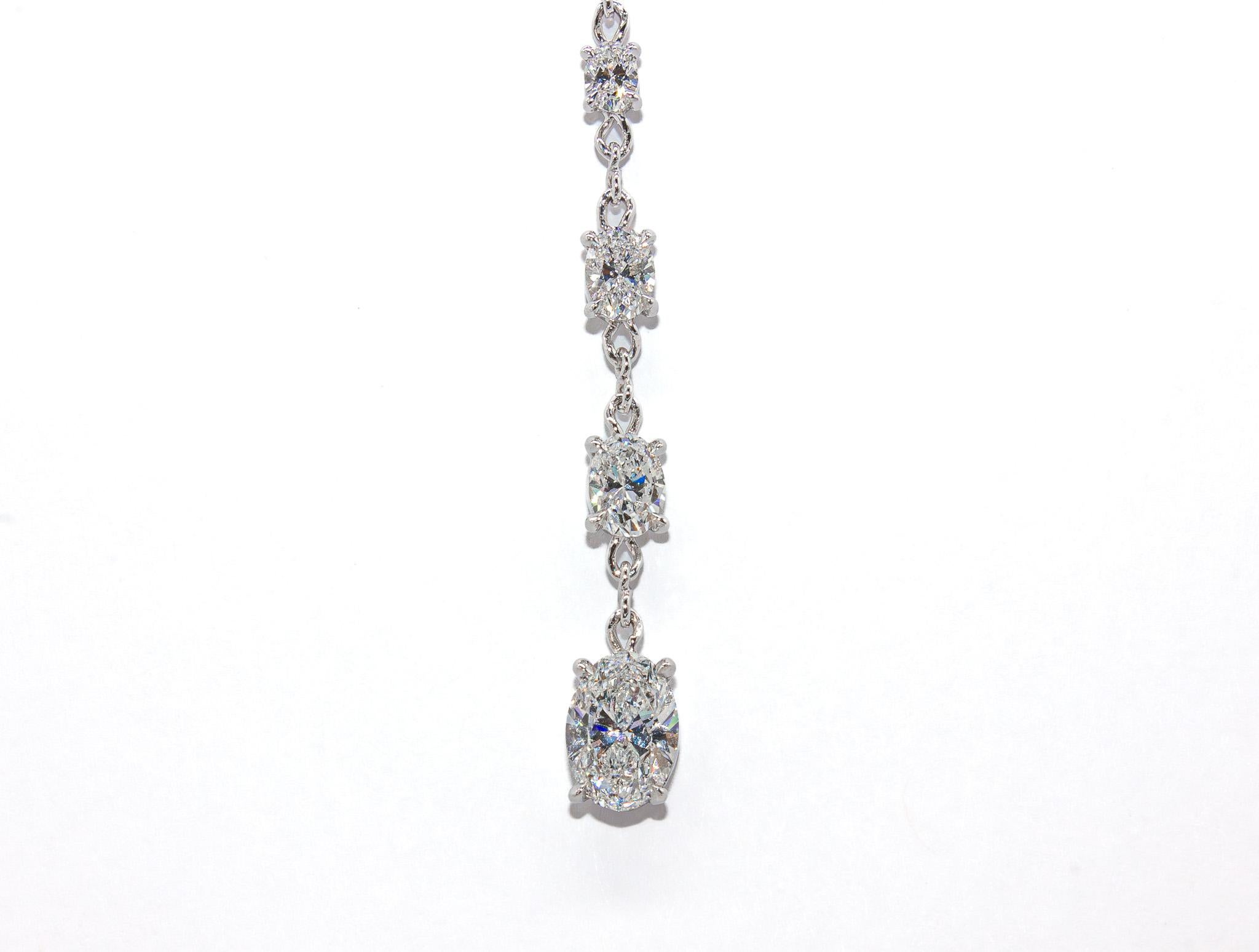 This elegant 14K white gold lariat-style necklace showcases a stunning display of brilliance and sophistication. The centerpiece features a 0.80 carat oval diamond (F SI2, GIA), radiating exceptional fire and sparkle. Suspended gracefully, the