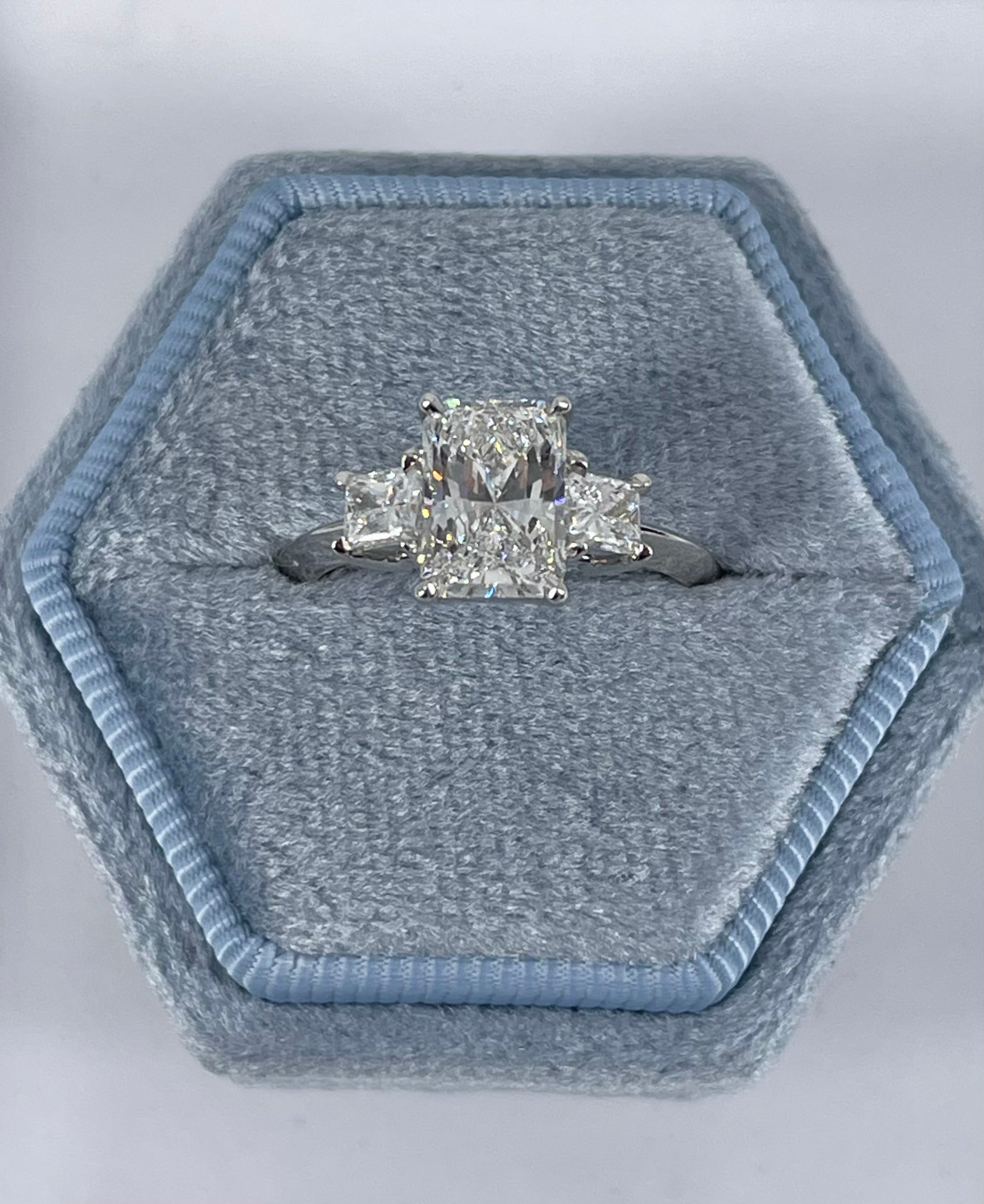 This gorgeous three stone engagement ring by J. Birnbach features a beautifully matched trio of radiant cut diamonds. The center diamond is 1.70 carats, GIA certified F color and VVS1 clarity. A colorless diamond with an exceptionally high clarity