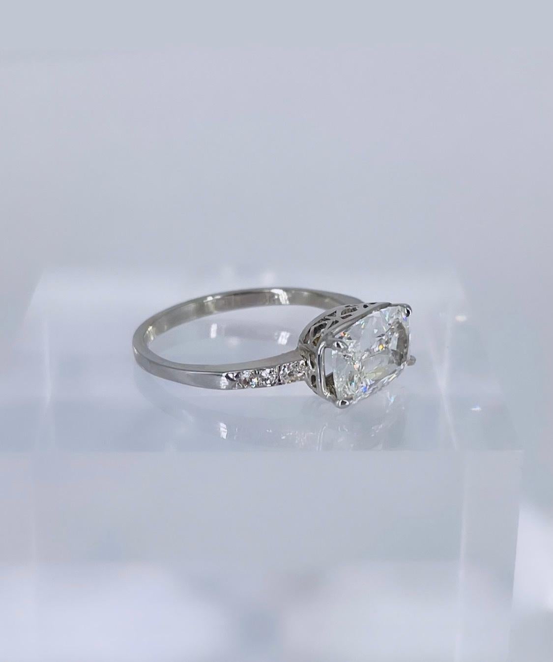 This sleek and elegant Art Deco ring is perfect for someone looking for a unique piece. This ring features an exceptionally elongated 1.71 carat cushion cut diamond with linear faceting that gives it a subtle mirror-like shine, which is truly