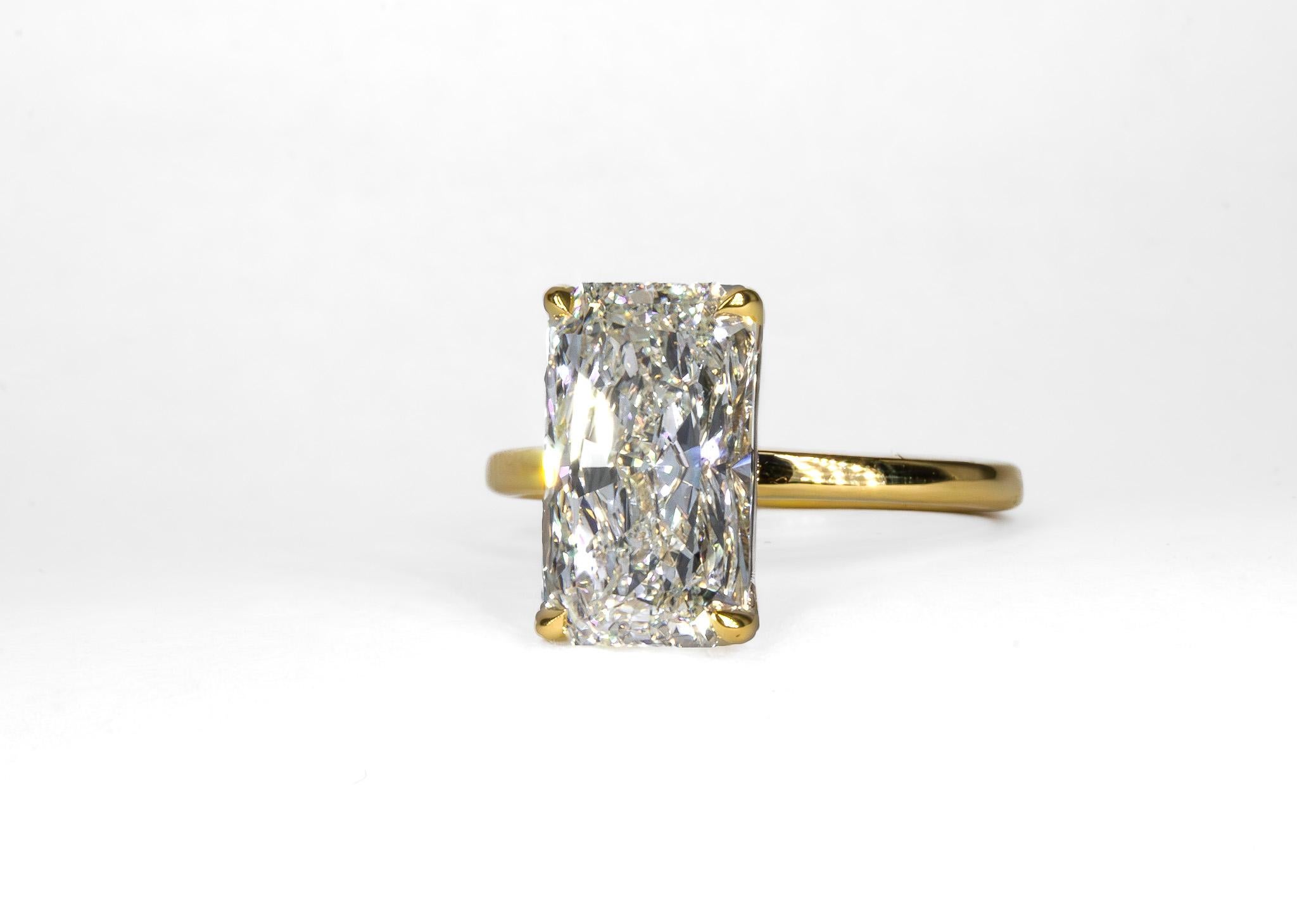 Cette élégante bague solitaire en or jaune 18 carats est une déclaration intemporelle de sophistication et de charme. La pierre centrale, un superbe diamant de 4,01 carats à taille radieuse, poli par des experts et classé K VVS2 par GIA, rayonne de