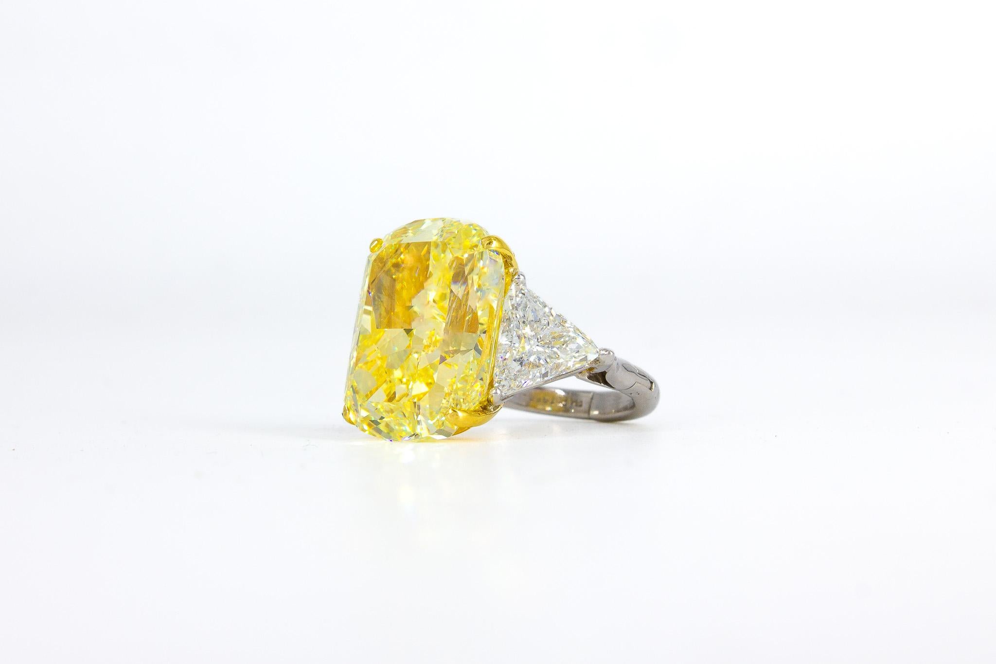 Faites passer votre collection de bijoux fins à la vitesse supérieure avec cette exceptionnelle bague à trois pierres en diamant taille coussin de 20,06 carats de couleur jaune intense fantaisie. Montée sur une monture sécurisée en platine et en or