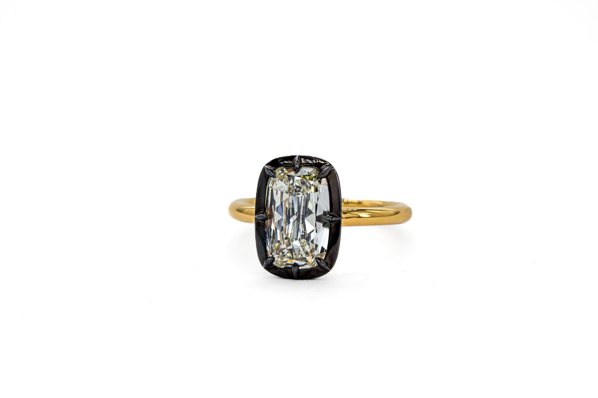 This striking two-tone Platinum and 18K Yellow Gold solitaire ring blends modern edge with timeless sophistication. At its center sits a mesmerizing 2.01 carat cushion brilliant diamond, GIA certified L color and SI1 clarity, set within a black