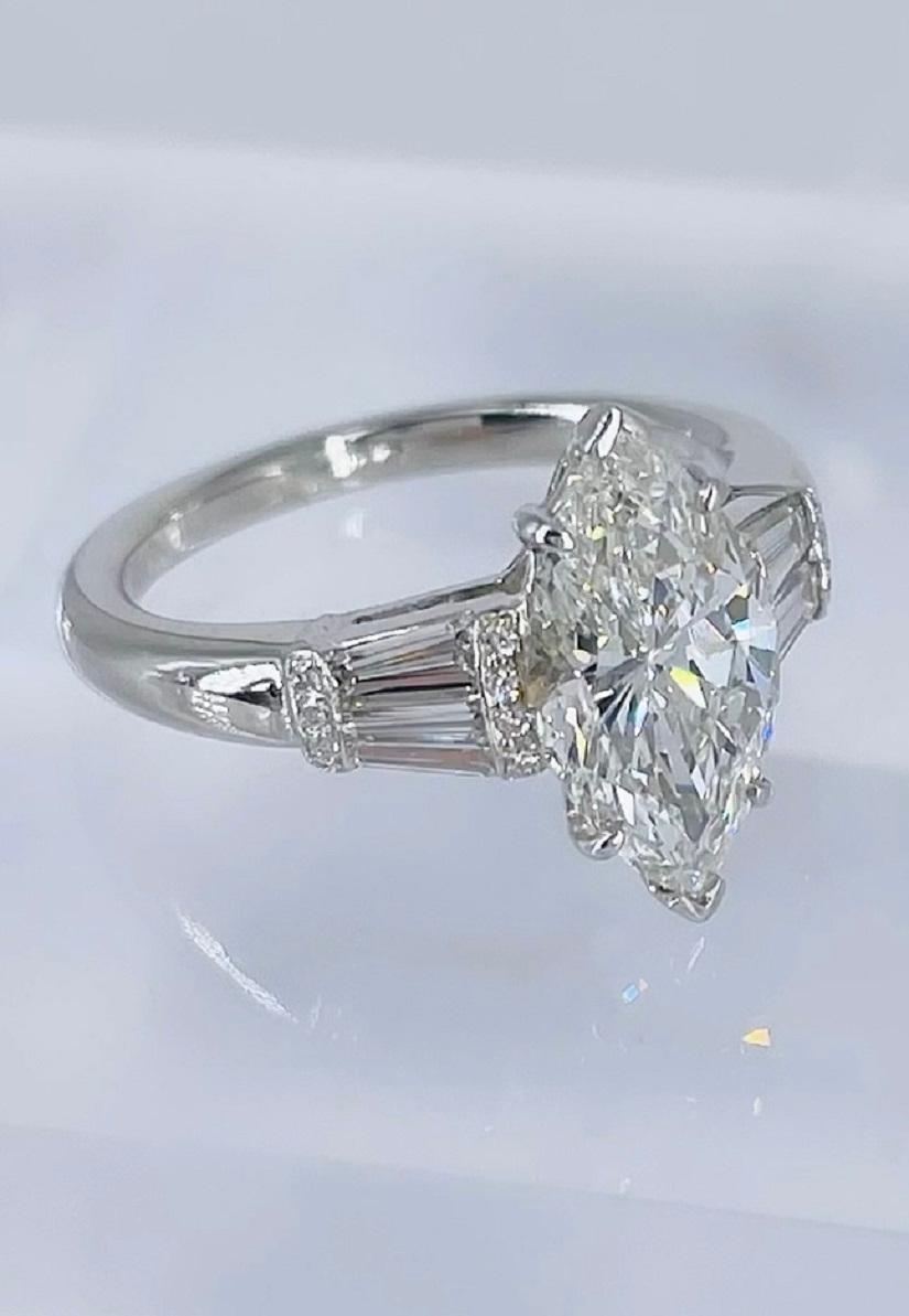 This unique piece by J. Birnbach features a 2.07 carat marquise shape diamond, certified by GIA as H color and SI1 clarity. The center diamond is accented by tapered baguettes with a pave outline. The baguettes and pave diamonds total 0.68 carats.