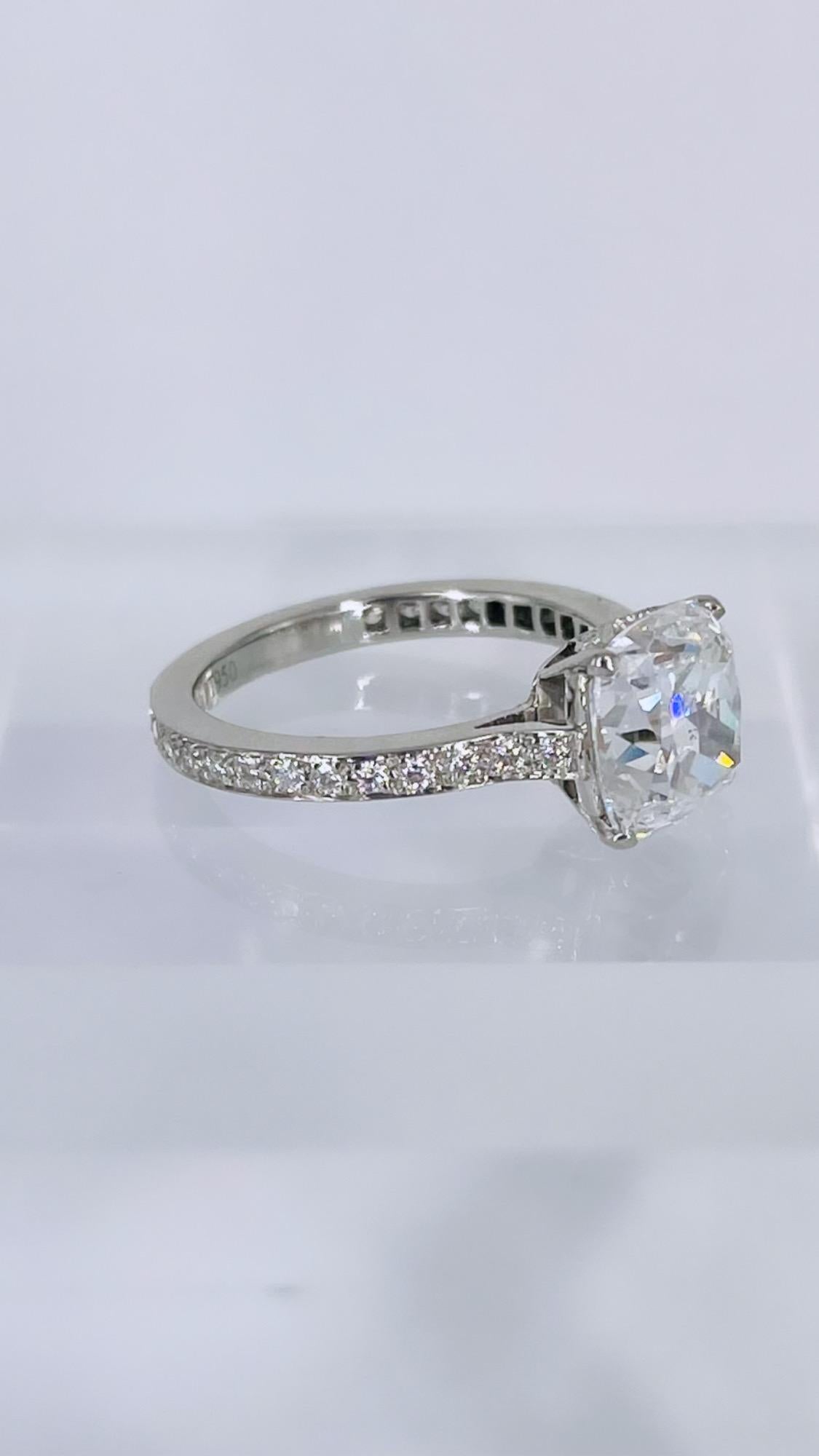 This engagement ring by J. Birnbach is a luxurious piece inspired by antique craftsmanship and details. The center diamond is a 2.68 carat brilliant cut cushion, certified by GIA to be E color and SI1 clarity. The larger facets give the diamond an