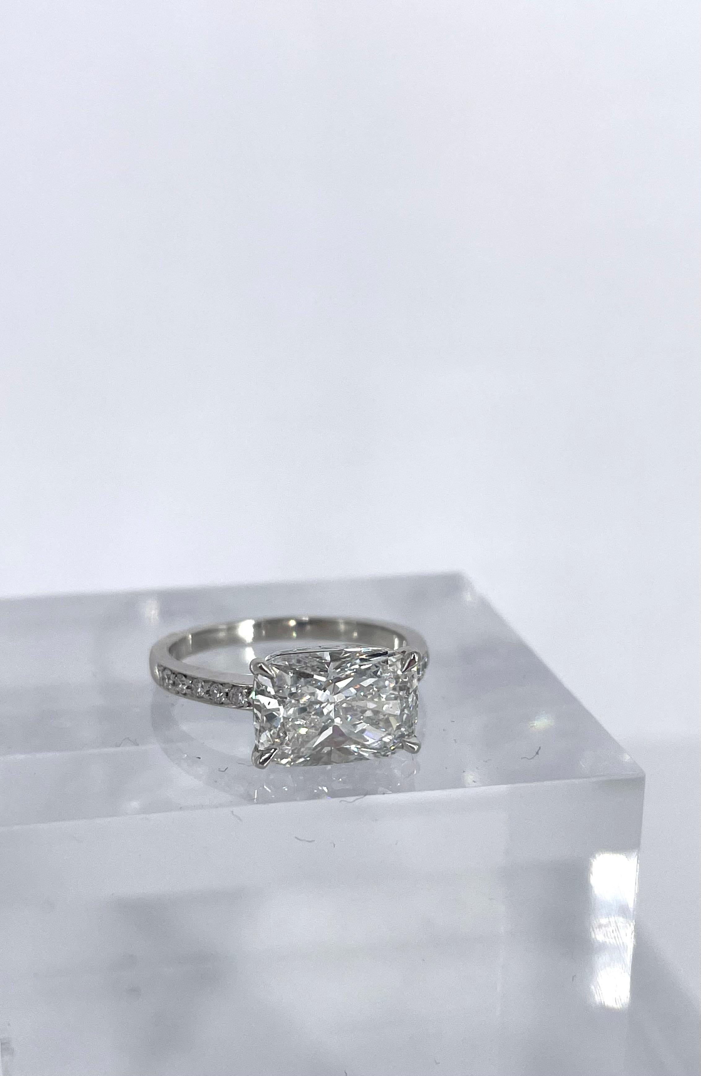 This east-west pave solitaire engagement ring is a unique combination of Art Deco touches and contemporary flair. The center diamond is an exceptionally elongated cushion, certified by the GIA to be 3.01 carats, E color and SI1 clarity. Crafted in