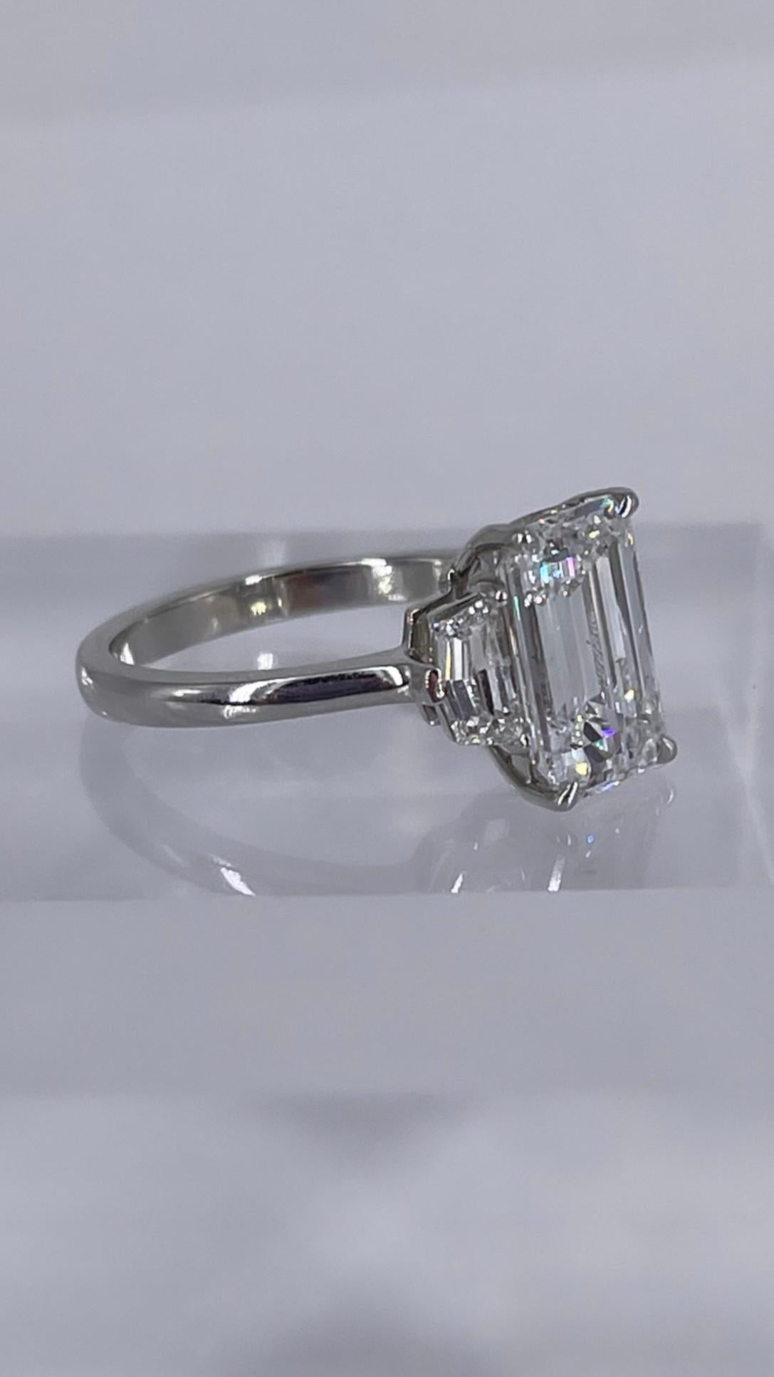 This sophisticated engagement ring by J. Birnbach features a sleek and exceptionally elongated emerald cut diamond, certified by GIA to be 3.01 carats, D color and SI1 clarity. The elegant center diamond is accented by epaulette side stones, which