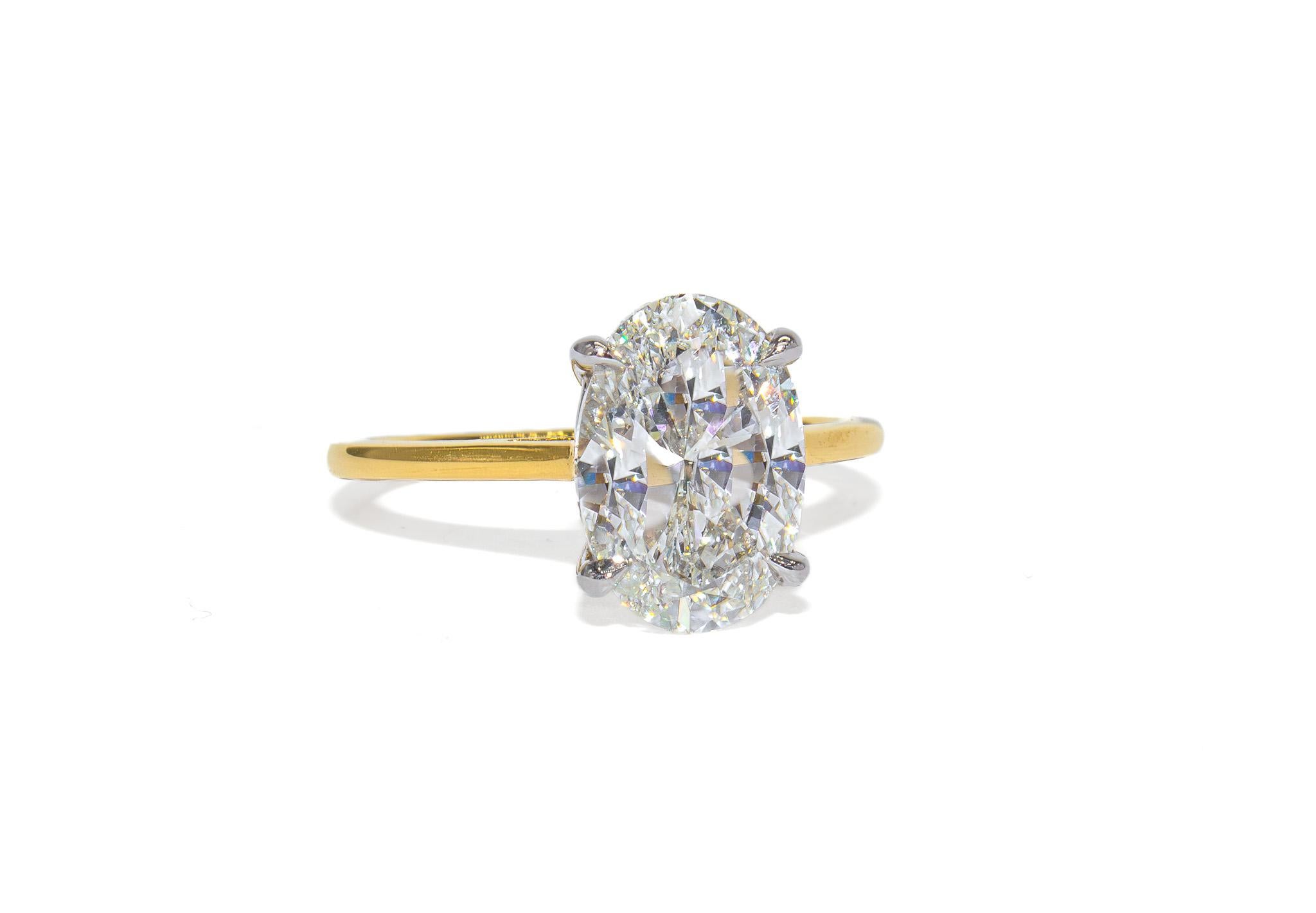 Este impresionante anillo solitario de J. Birnbach exhibe un impresionante diamante ovalado de 3,01 quilates, certificado por el GIA con color G y claridad VS1. El brillo excepcional del diamante y su forma alargada crean un aspecto favorecedor y