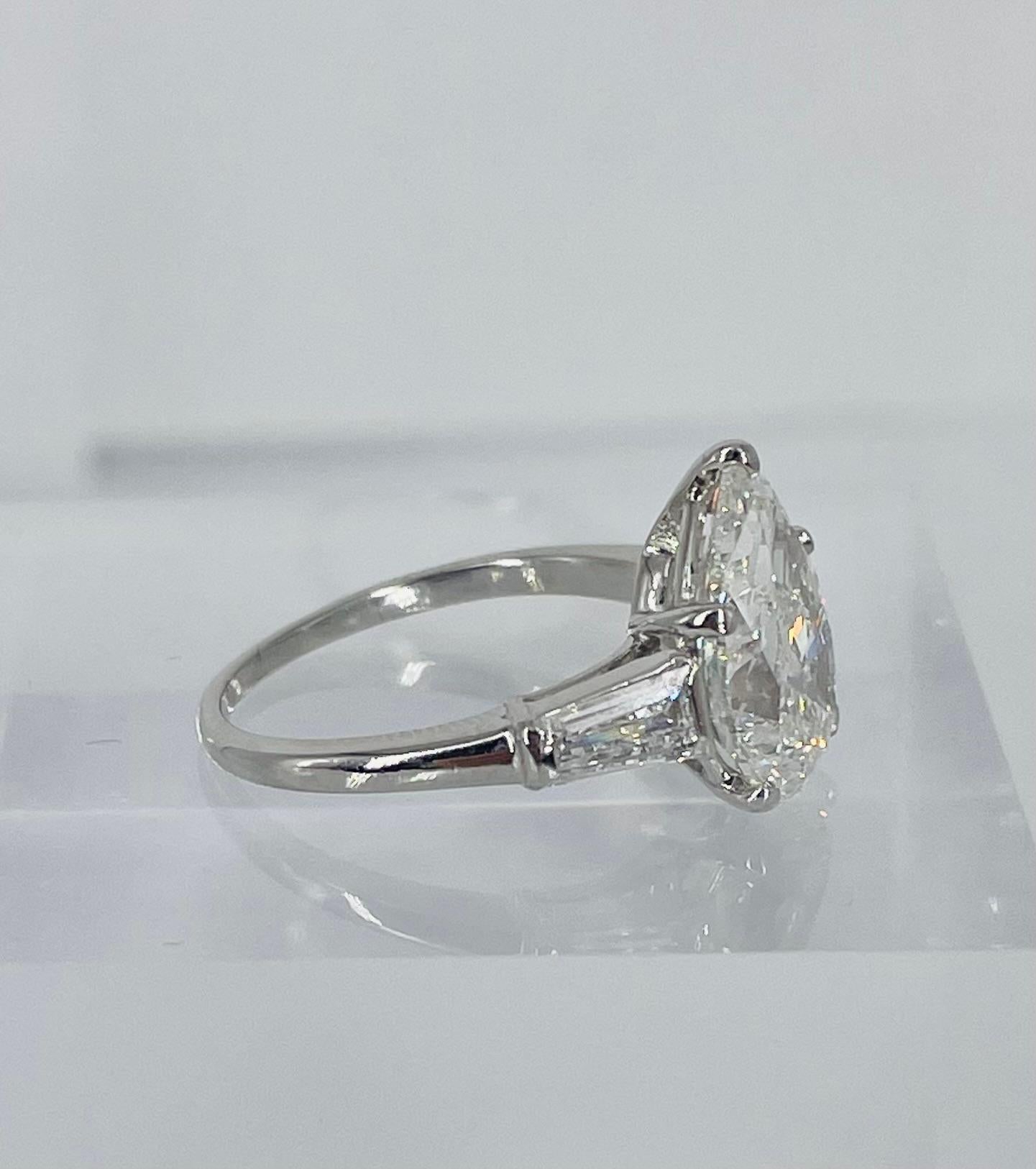 A timeless classic, this three stone engagement ring by J. Birnbach is a lovely statement piece. The center diamond is a GIA certified 3.02 carat pear shape, with H color and SI2 clarity. This pear shape has a gorgeous full proportion, making it