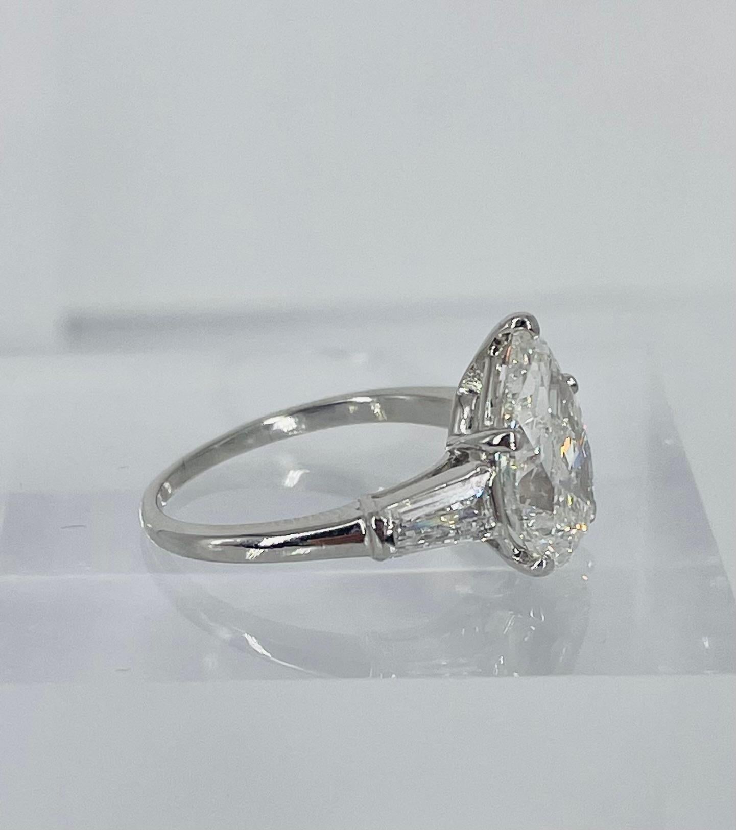 A timeless classic, this three stone engagement ring by J. Birnbach is a lovely statement piece. The center diamond is a GIA certified 3.02 carat pear shape, with H color and SI2 clarity. This pear shape has a gorgeous full proportion, making it