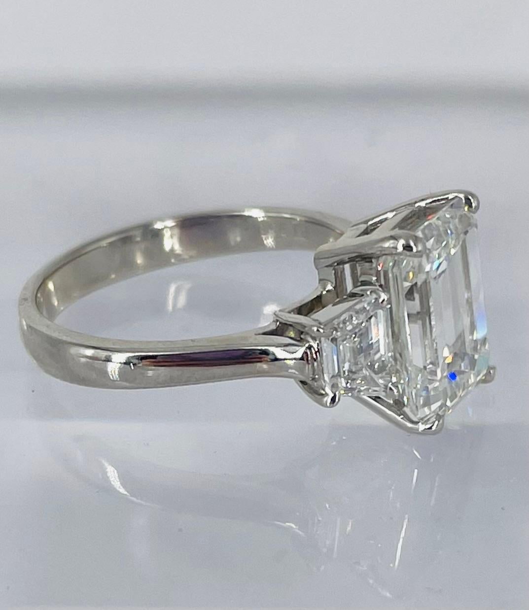 This exquisite engagement ring by J. Birnbach is a sleek and modern execution of a classic! The center diamond is a 3.14 carat GIA certified emerald cut with F color and SI1 clarity. The emerald cut is a beautiful, slightly elongated proportion that