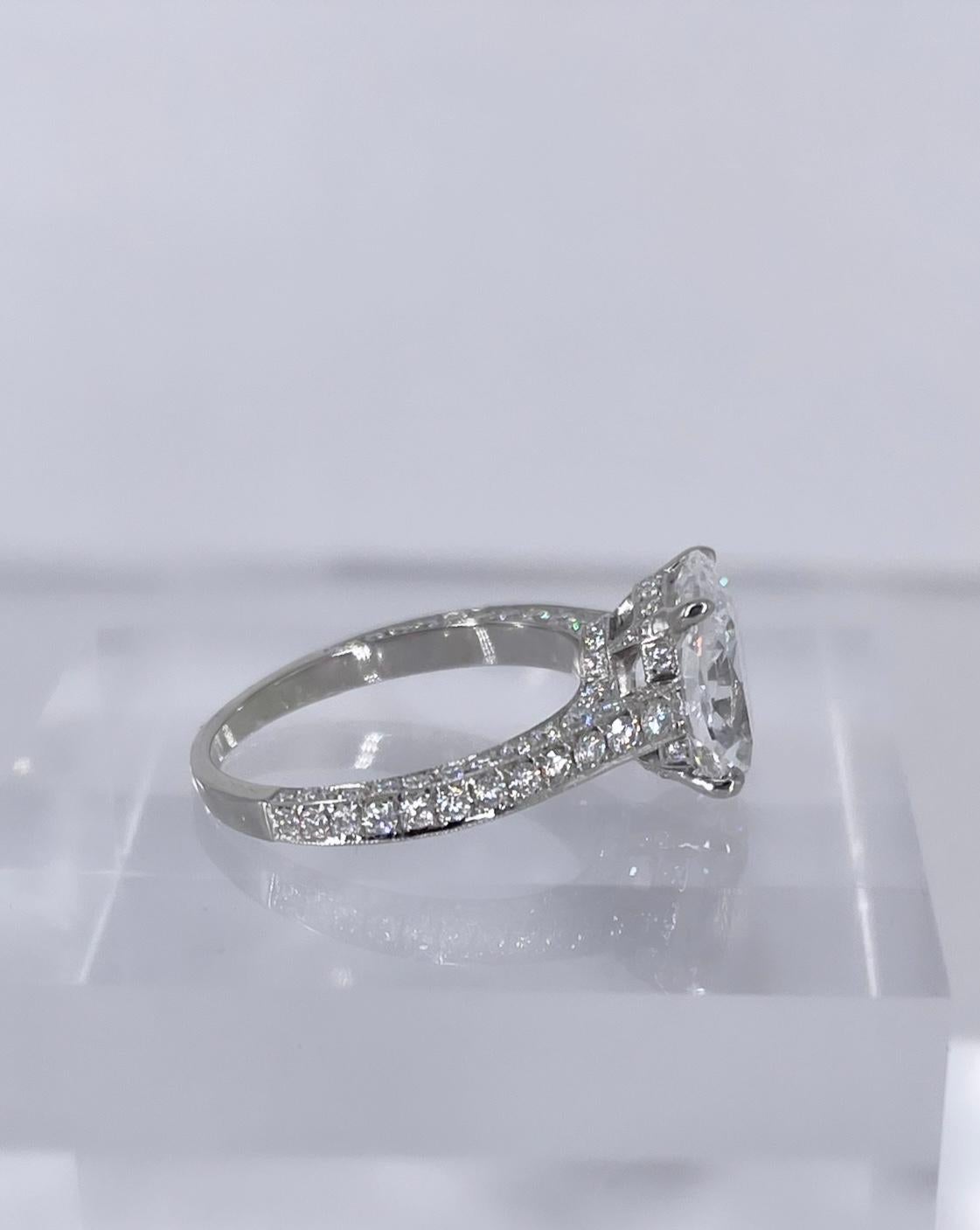This engagement ring pairs an exceptional diamond with detailed craftsmanship. The stunning center diamond is a 3.18 carat cushion brilliant, certified by GIA to be D color and SI1 clarity. This is a very special and rare diamond; not only does it