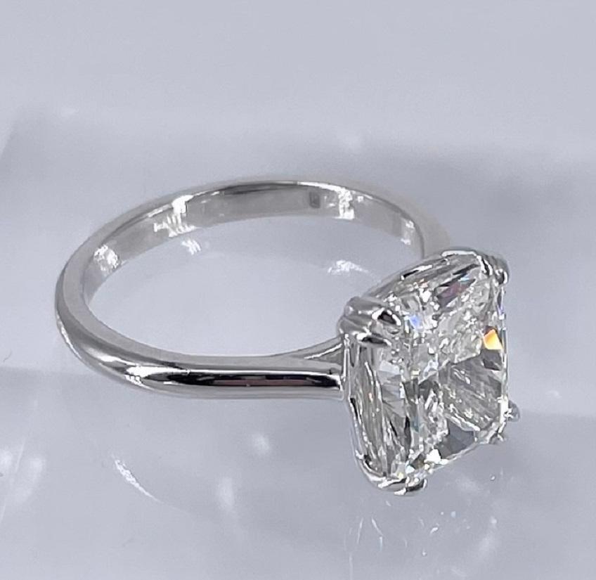 This sleek, modern solitaire features a sparling 3.54 carat radiant cut diamond. It is certified by GIA as I color and SI1 clarity. The handmade platinum ring is a cathedral style solitaire that will sit flush with most wedding bands. The petite