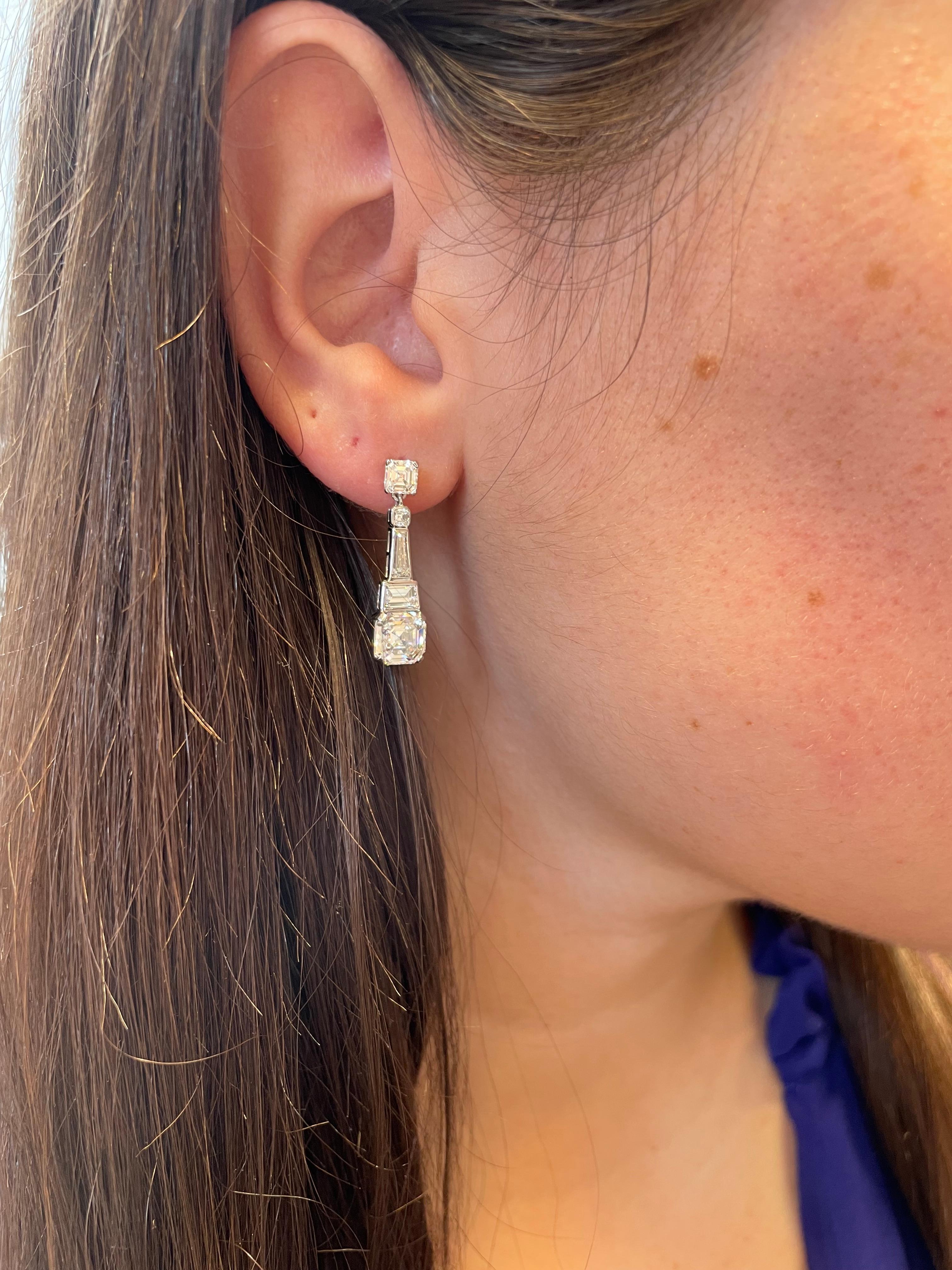 These elegant earrings by J. Birnbach are a stunning celebration of the Art Deco aesthetic. The earrings contain Asscher cuts, tapered baguettes, and step cut trapezoid diamonds. The combination of a variety of step cut diamonds creates a sleek and