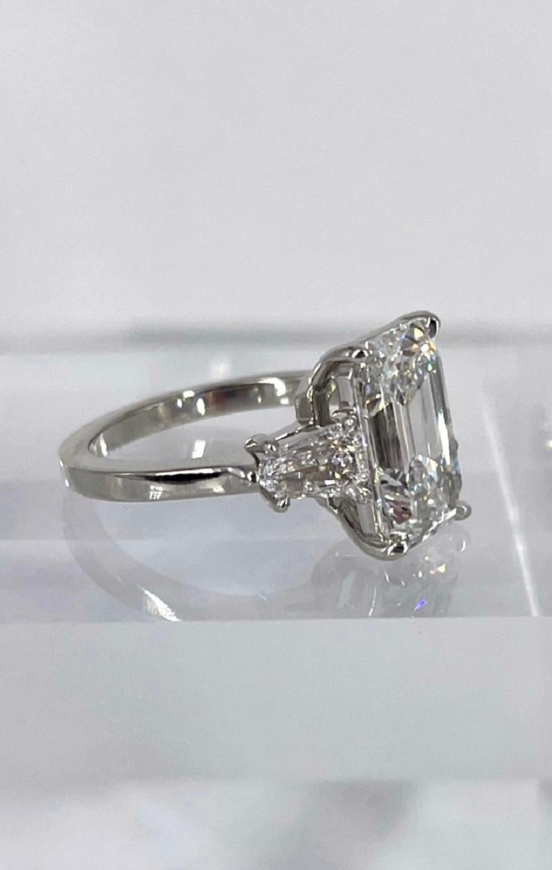 This stunning emerald cut diamond engagement ring is J. Birnbach's unique take on a classic style. The timeless three stone engagement ring is given a fresh twist thanks to the unusually narrow and elongated center diamond. The 3.61 carat emerald
