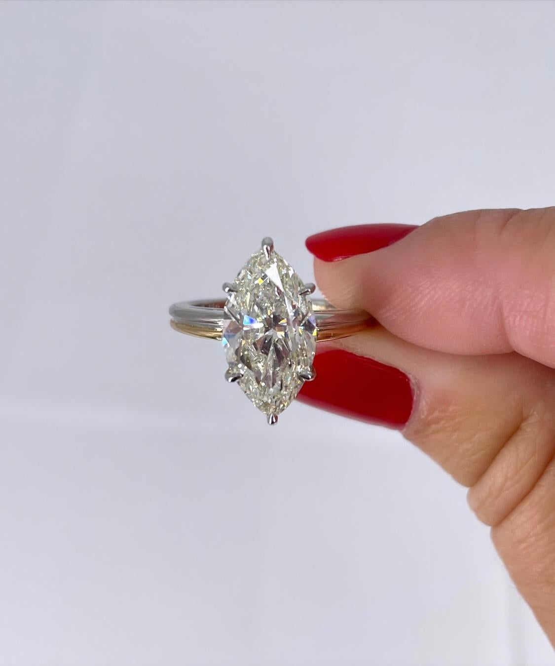 This stunning solitaire features a 3.72 carat marquise diamond, certified by GIA to be L color and SI2 clarity. The unique two-tone setting has a 2.3mm double band in platinum and 18K yellow gold. The platinum basket cradling the diamond is airy and