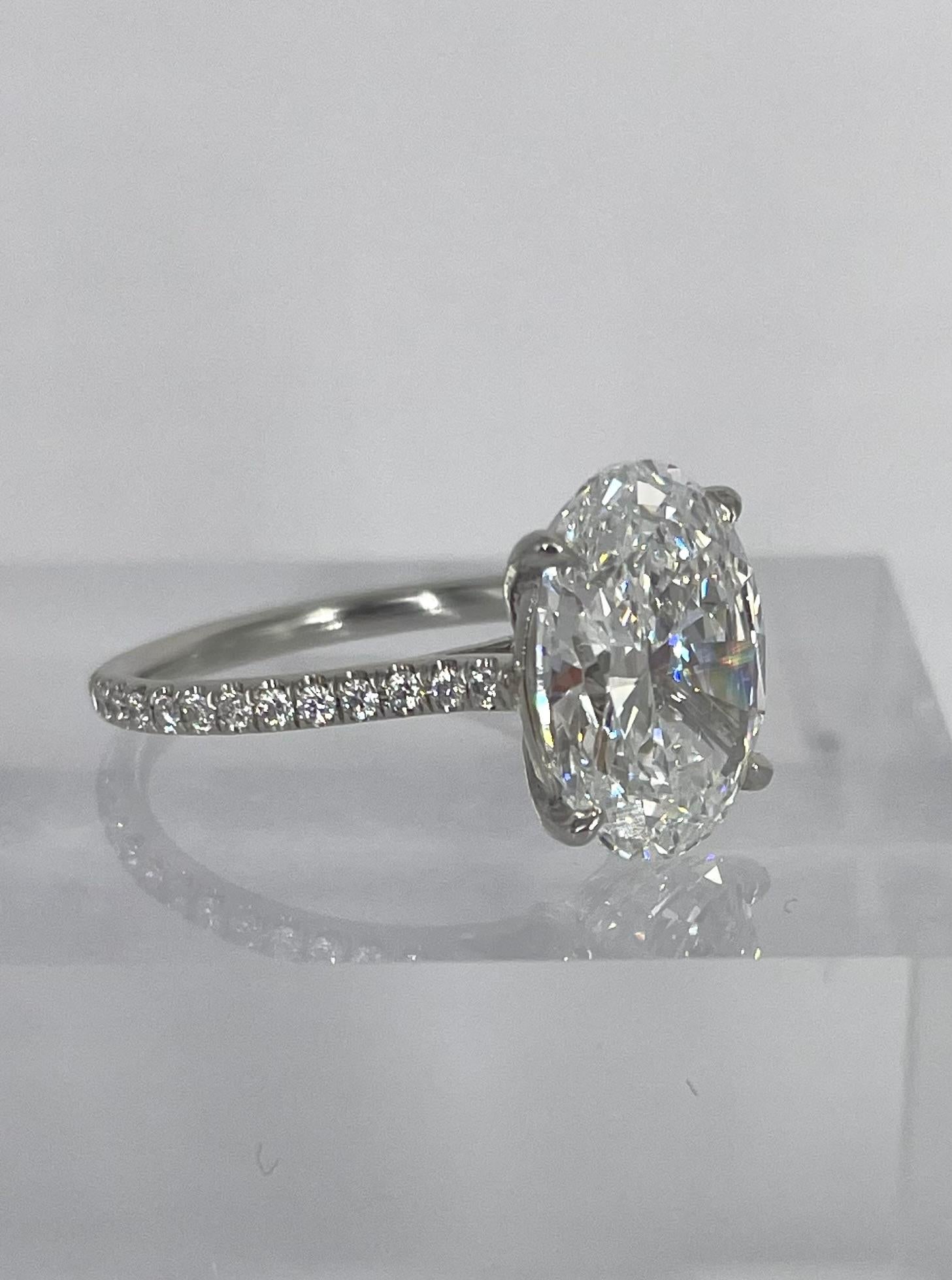Delicate, feminine and romantic, this oval pave solitaire is perfect for someone looking for timeless sparkle. The 4.22 carat oval diamond is certified by GIA to be E color and VS1 clarity. This rare combination of high color and clarity and the
