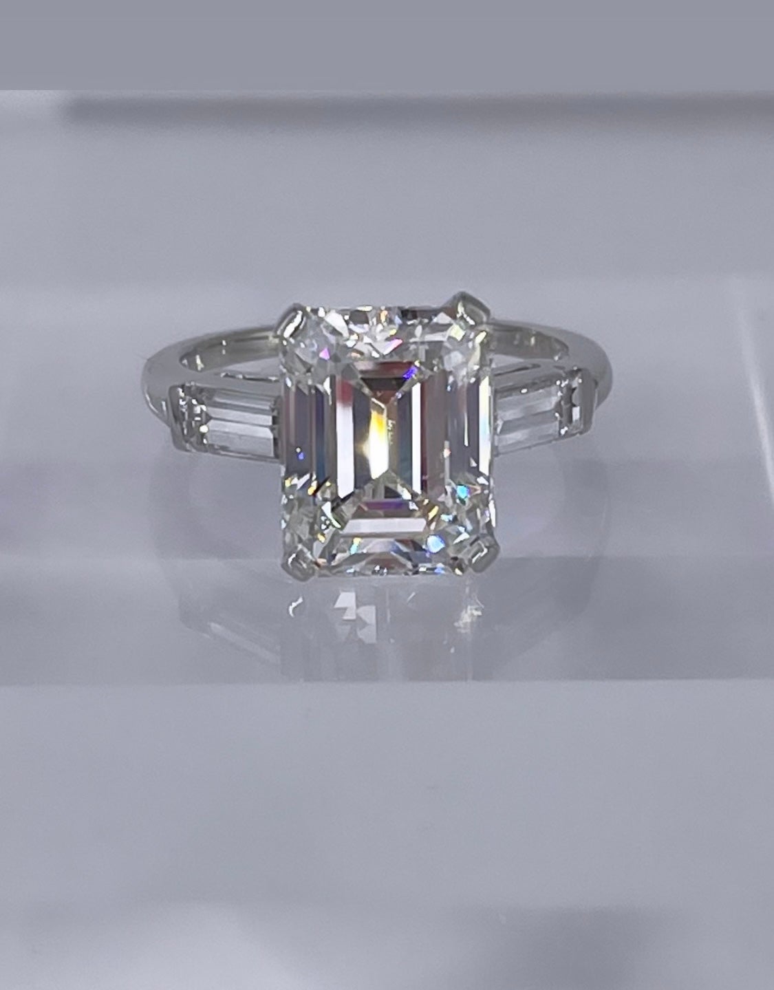This timeless engagement ring by J. Birnbach is inspired by the clean lines of Art Deco design. The ring features a 4.77 carat emerald cut diamond, GIA certified J color and VS1 clarity. Because of an emerald cut's faceting, the diamond appears