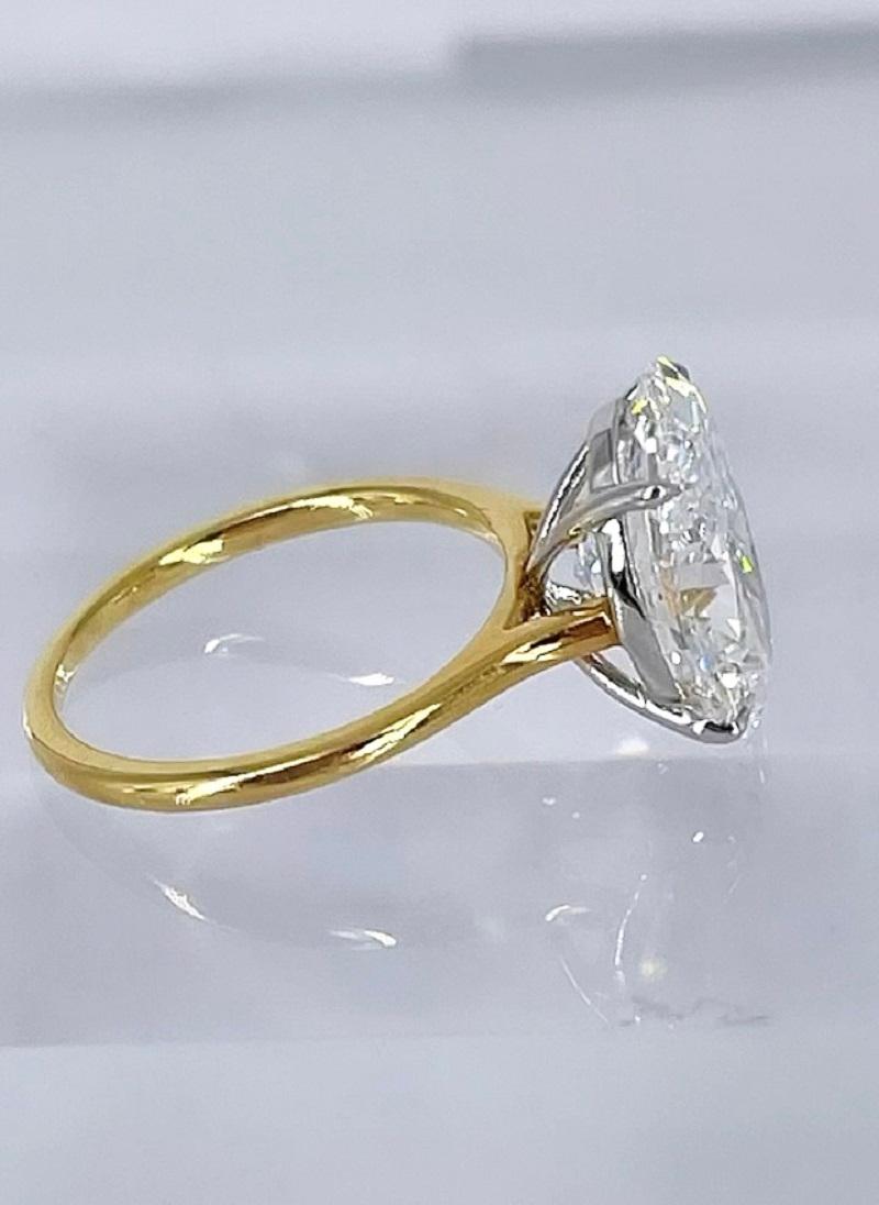 This gorgeous solitaire by J. Birnbach features a 5.19 carat oval diamond certified by GIA to be E color and SI1 clarity. E color is within the colorless range, making this a rare and special piece. Sparkling and bright, the diamond is a beautifully