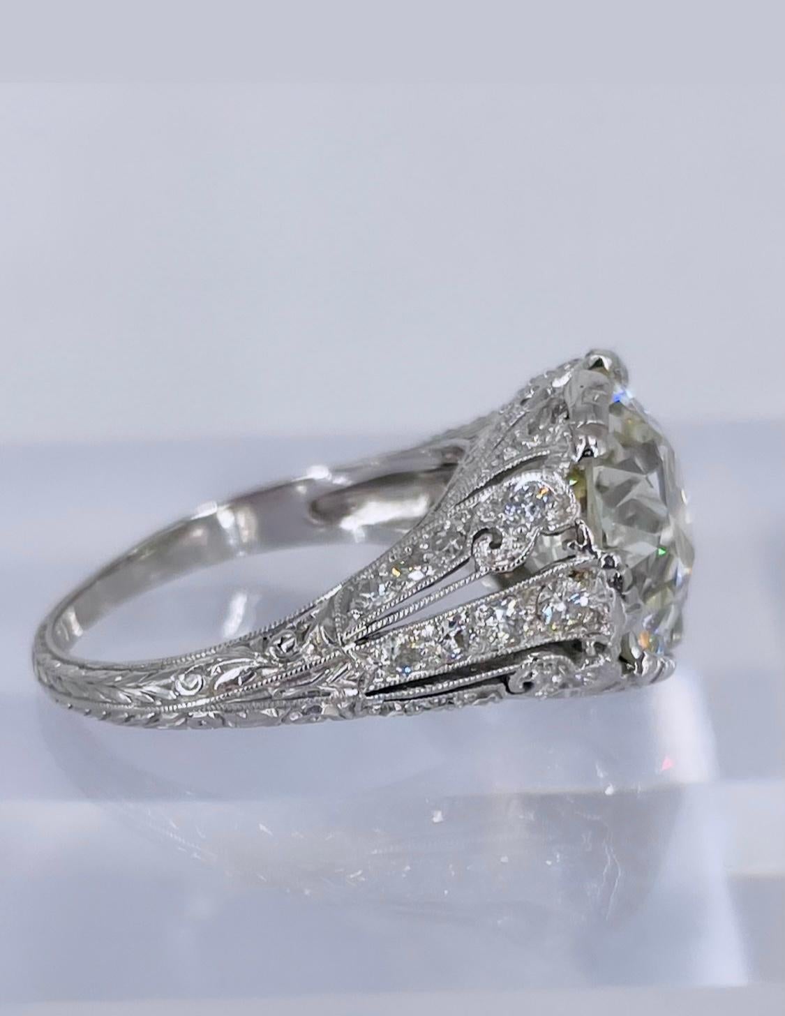 This exquisite antique platinum ring features all of the detail, craftsmanship and charm of the Art Deco period. The diamond is a gorgeous 5.57 carat European cut certified by GIA as L color and VS2 clarity. The diamond appears significantly whiter