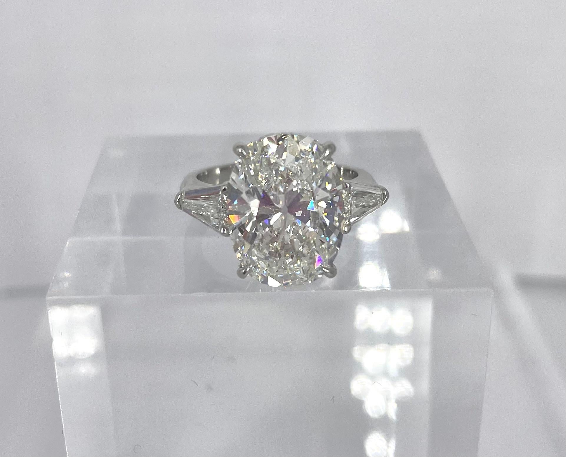 This gorgeous engagement ring showcases a magnificent 7.03 carat cushion diamond, certified by the GIA to be G color and VS1 clarity. This is an exceptional stone because it is unusually elongated and curved, giving the flattering length of an oval