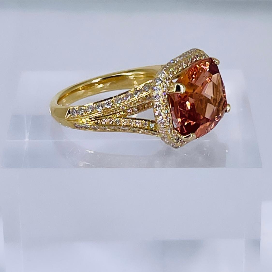 This luxurious ring by J. Birnbach is a gorgeous combination of color and sparkle. The 8.85 carat orange elongated cushion cut topaz is a rich, warm orange with an even saturation and distribution of color. The topaz is framed by an exquisite halo