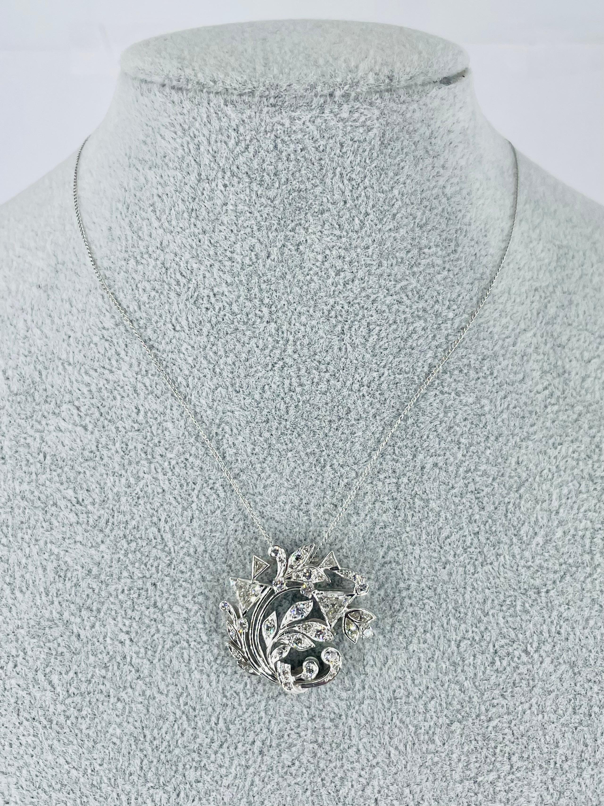 Dieser Anhänger aus den 1950er Jahren aus dem J. Birnbach-Gewölbe ist ein glamouröses, zeitloses Stück. Das asymmetrische Rankenmuster enthält eine Vielzahl von Diamantschliffen: zwei große dreieckige Diamanten (1,25 Karat), Marquise, runde und