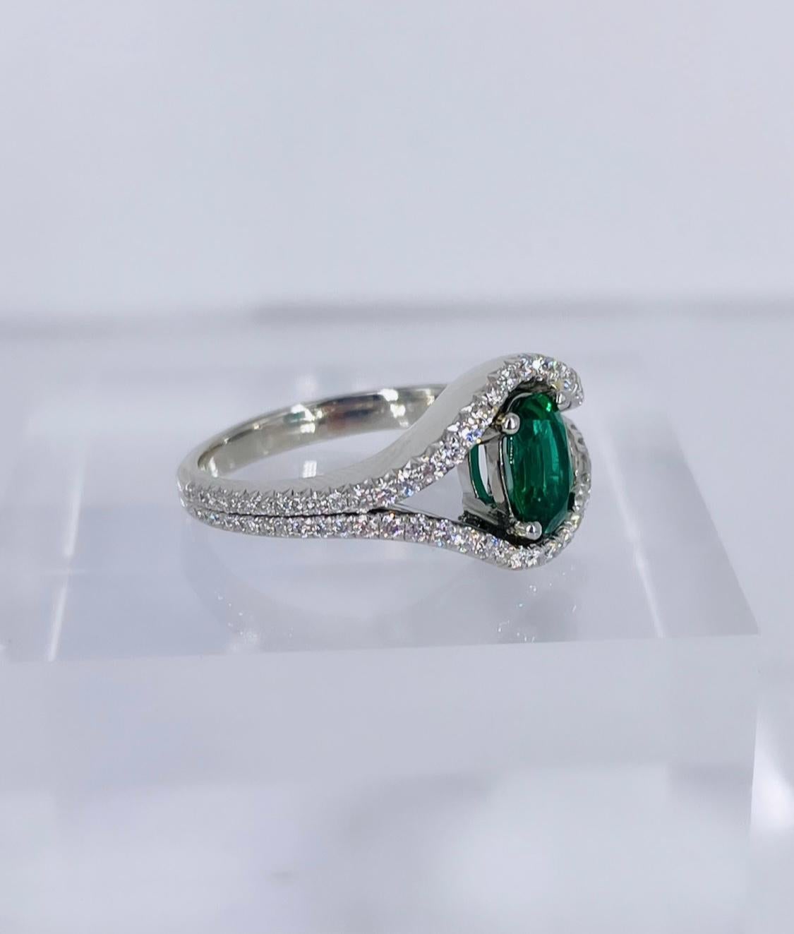 This unique diamond and emerald ring is a stunning addition to any jewelry collection! The oval emerald is a rich, very saturated green, which is a luxurious contrast against the bright white diamonds and platinum. Sleek enough for everyday wear but