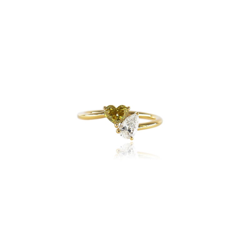This sweet ring fresh from the J. Birnbach workshop features a 0.51 carat heart shape diamond of fancy greenish yellow color and SI1 clarity paired with a 0.40 carat pear shape diamond of F color and SI1 clarity. Both diamonds possess a beautiful, 