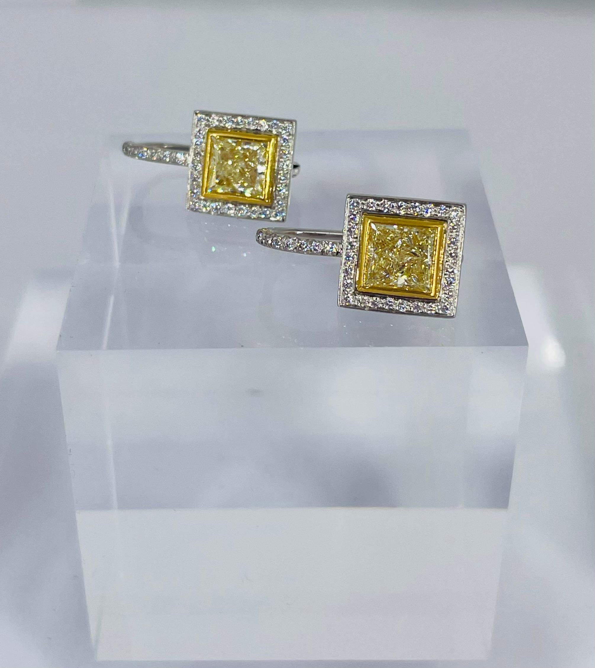 These sophisticated earrings by J. Birnbach are the perfect piece to add sparkle and color to any ensemble! Striking and sleek, this pair of earrings features fancy yellow princess cut diamonds (total 1.90 carats) with a white pave halo frame. The