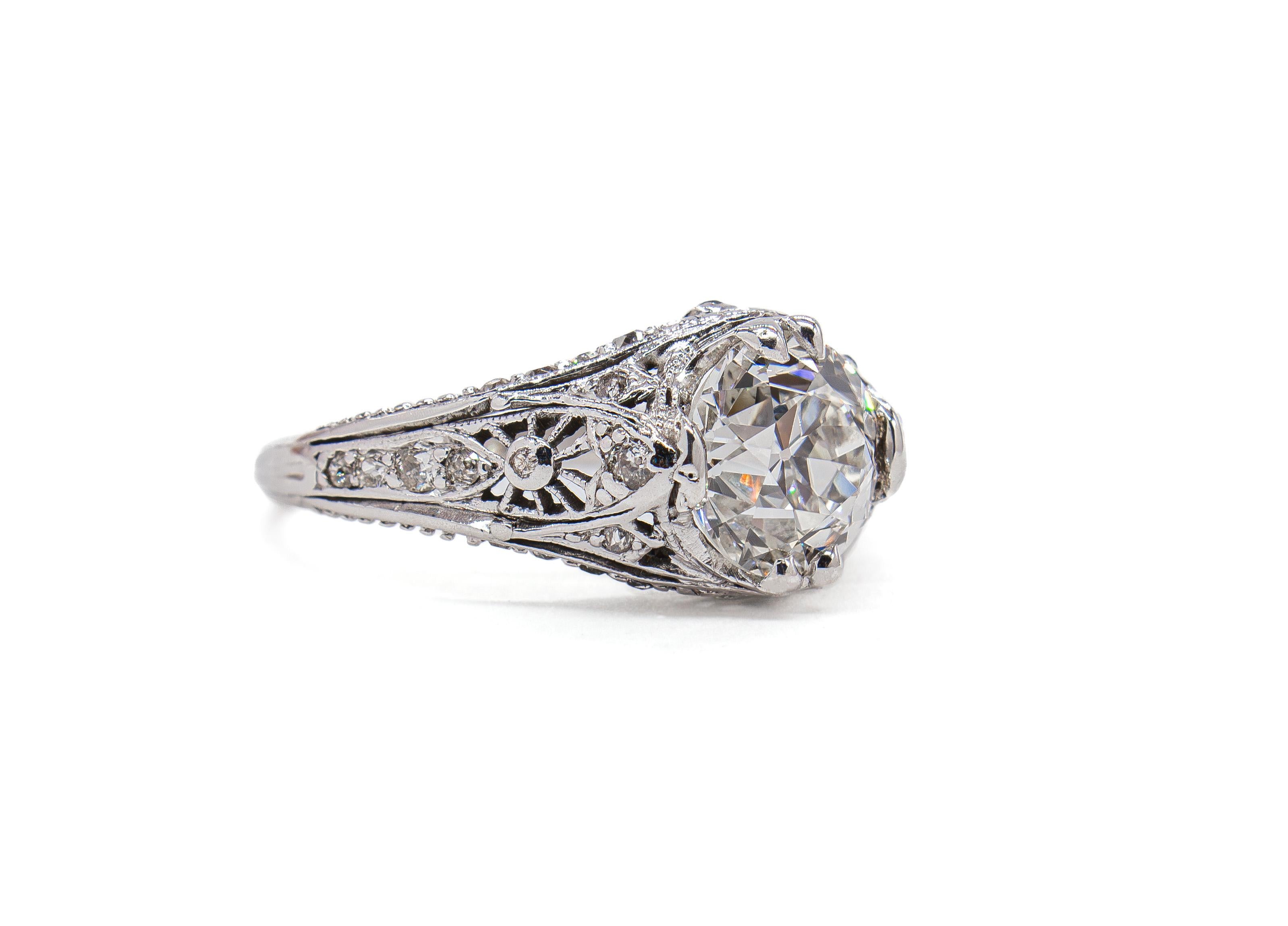 This elegant platinum Art Deco–style ring beautifully blends antique inspiration with timeless sophistication. At the center sits a 1.58 carat Old European cut diamond, certified by GIA as G color and VS1 clarity. The diamond is encircled by