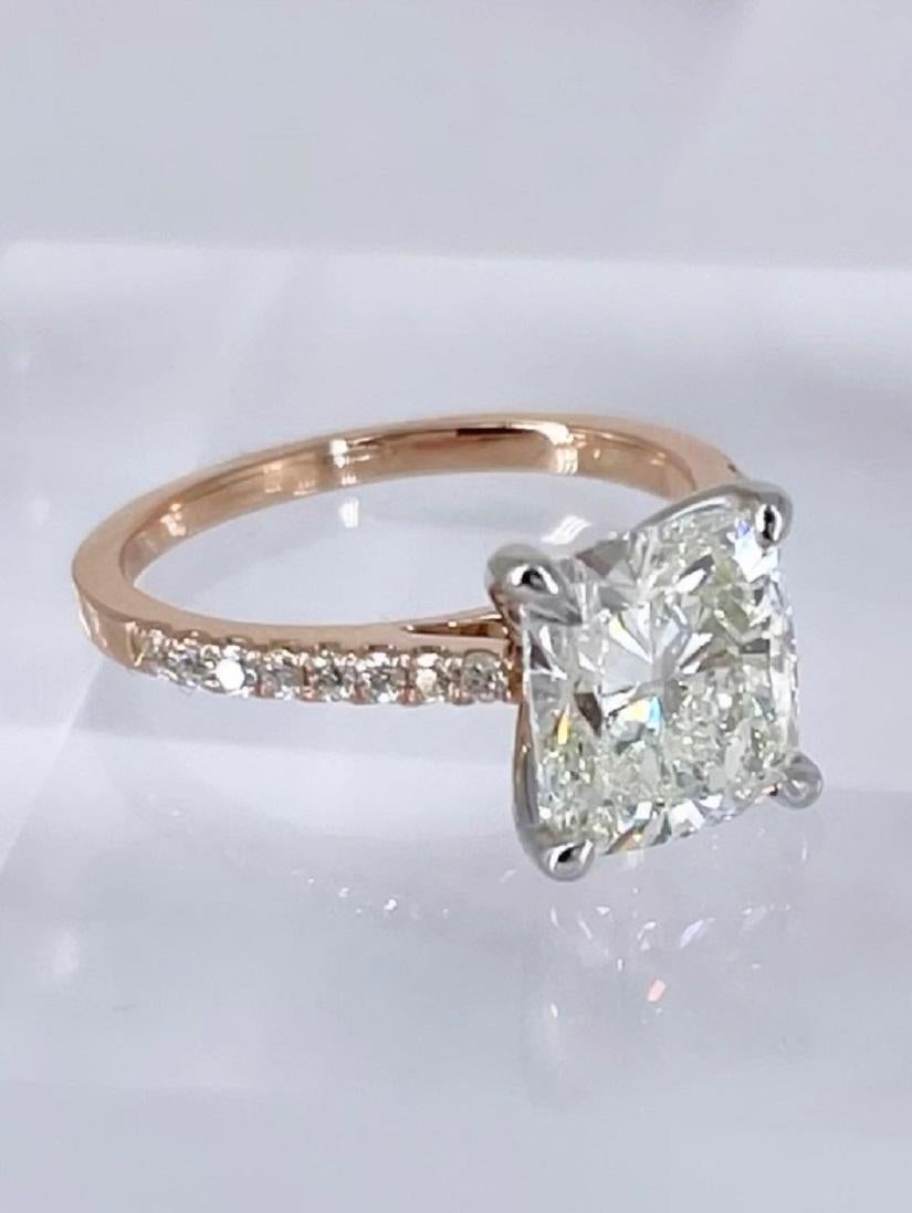 This sparkling engagement ring by J. Birnbach features a 3.01 carat cushion cut diamond certified by GIA as K color and SI1 clarity. The diamond is slightly elongated with great finger coverage. The prongs are crafted in white gold, and the band is
