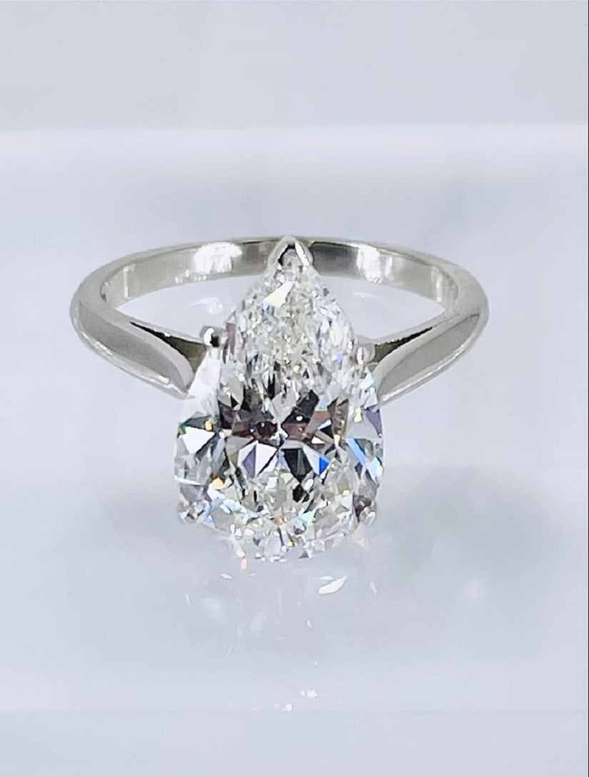Ce magnifique solitaire de J. Birnbach est orné d'un diamant poire de 4,41 carats, certifié par GIA de couleur G et de pureté SI1. La forme longue et élégante du diamant est parfaite pour un solitaire. Cette bague simple et classique permet au