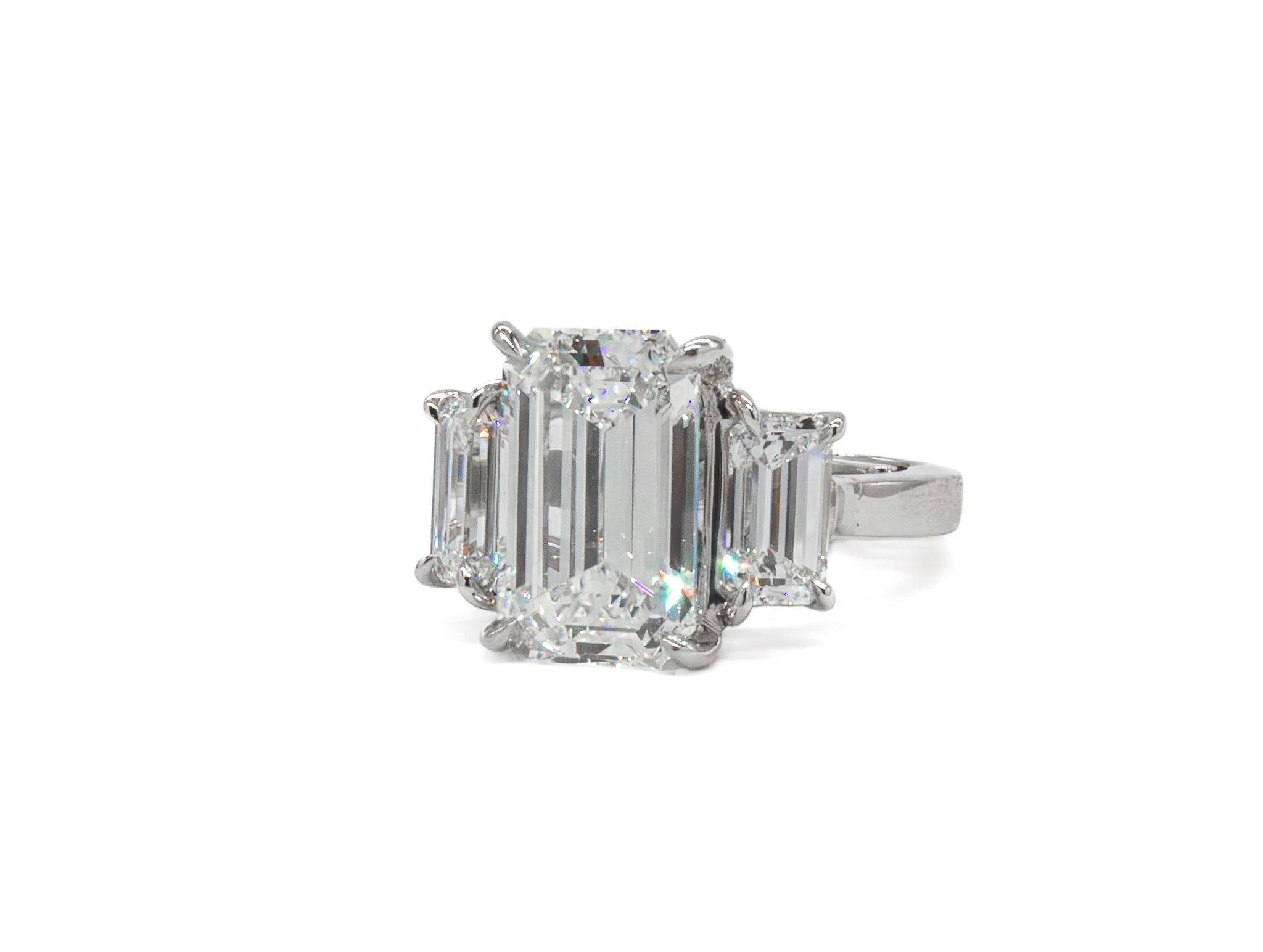 This handmade platinum ring is a refined statement of symmetry and elegance. At its center is a striking 4.49 carat emerald cut diamond, graded I color and VS2 clarity by GIA. Flanked by two beautifully matched emerald cut side stones totaling 1.77