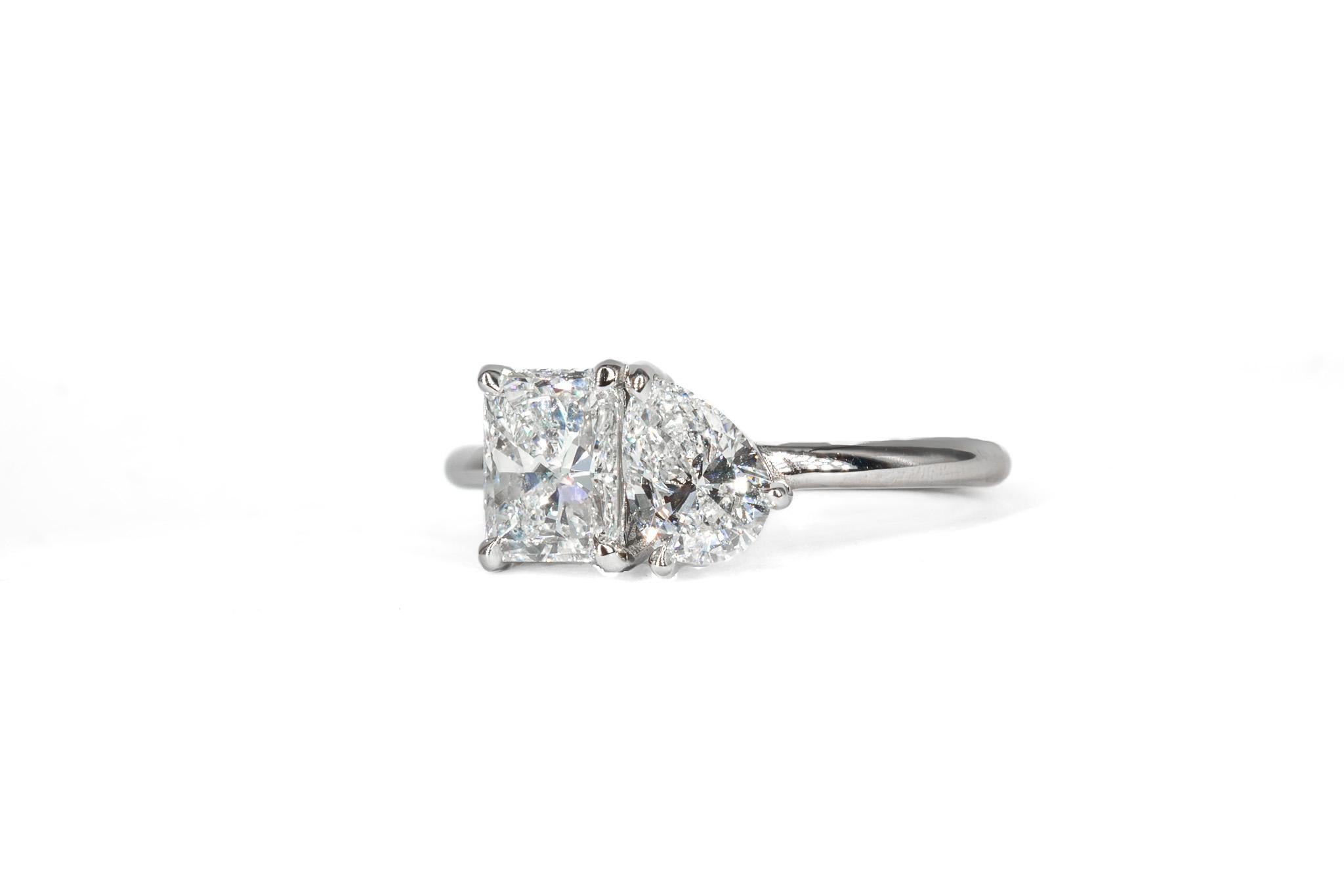This elegant platinum Toi et Moi ring features a beautifully paired duo of diamonds, symbolizing the union of two souls. The ring showcases a 0.90 carat radiant cut diamond, certified by GIA as I color  alongside a 0.51 carat pear shape diamond of G
