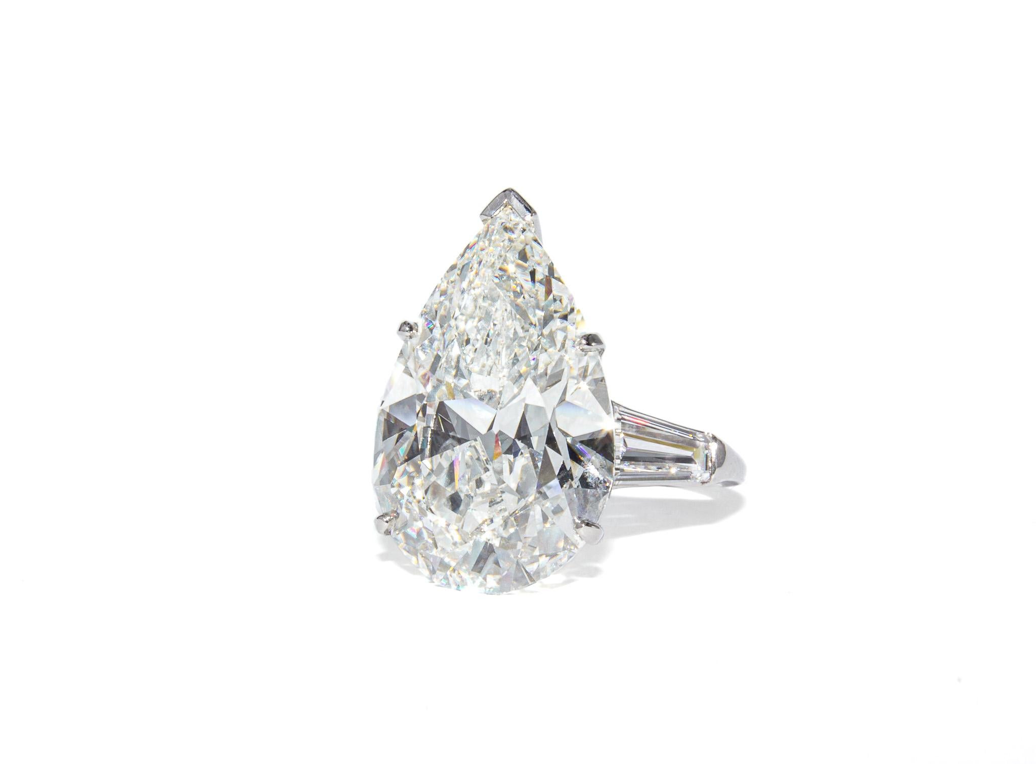 Este extraordinario anillo de tres piedras de J. Birnbach es una auténtica rareza, con un extraordinario diamante en forma de pera de 11,97 quilates, tan impresionante por su calidad como por su tamaño. Certificado por el GIA como de color I y