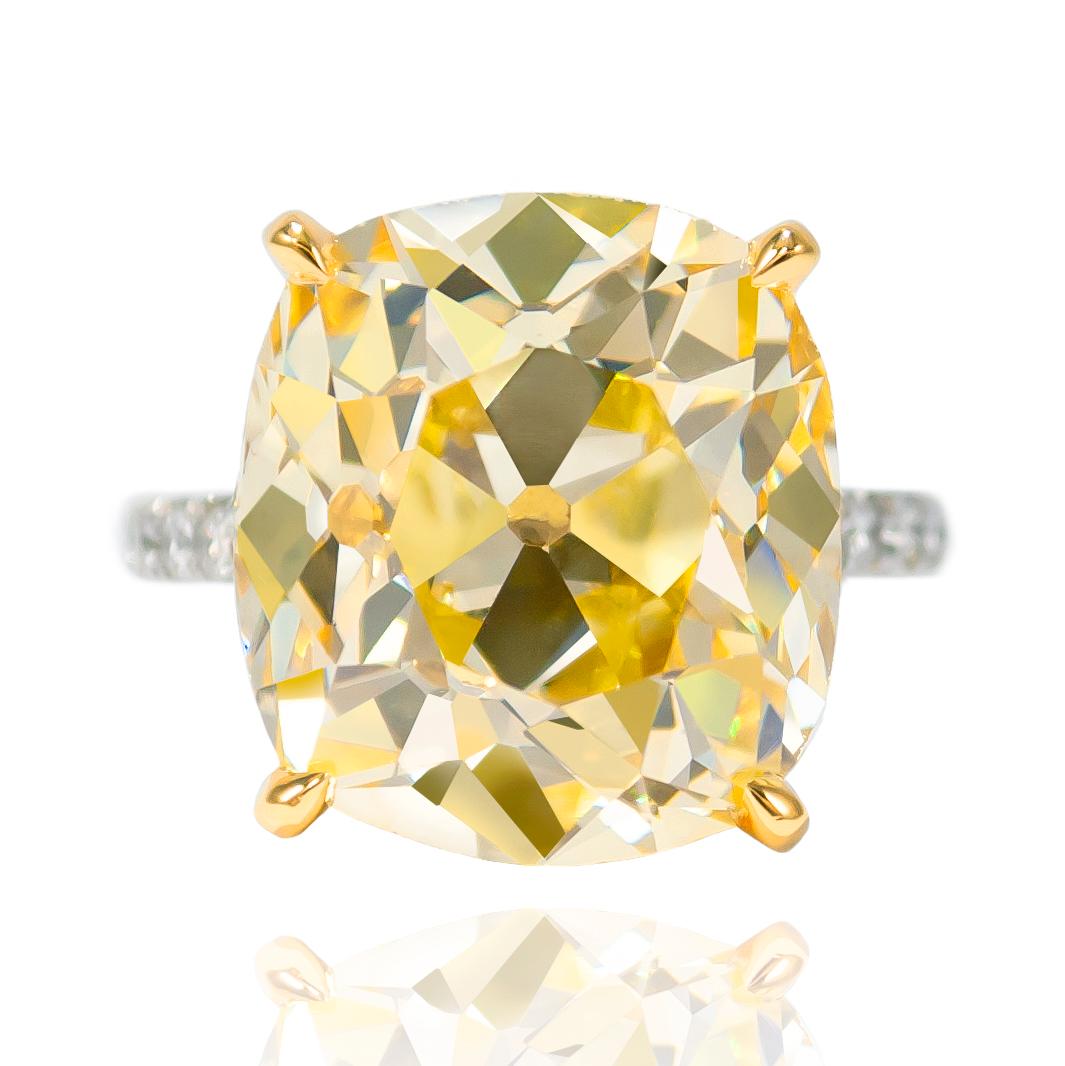 This incredible 14.46 ct Natural Fancy Yellow Old Mine Brilliant diamond is a once-in-a-lifetime stone.... Set in a handmade, Platinum & 18K Yellow Gold Ring with Fancy Yellow & White diamonds, this piece will garner stares for a lifetime! The ring