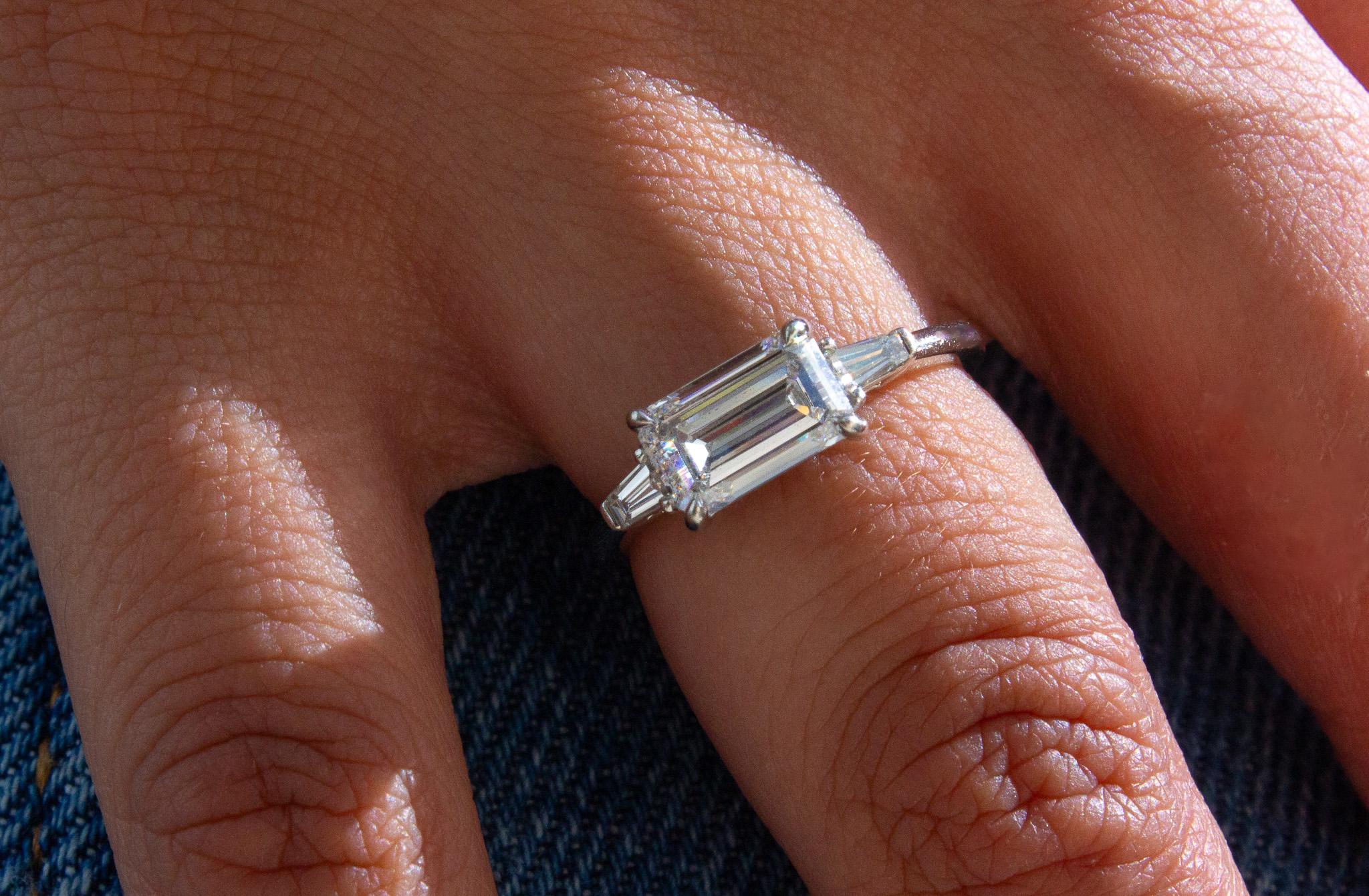 Capture timeless beauty with this stunning J. Birnbach Platinum Three-Stone Ring, featuring a GIA certified 1.51 carat Emerald Cut Diamond. With E color and VS1 clarity, the center diamond boasts exceptional brilliance and clarity, making it a