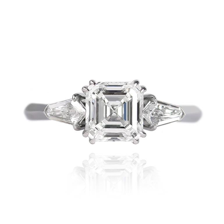 This sleek and sophisticated Asscher cut engagement ring is a unique take on a classic three stone ring. The geometric combination of shapes is edgy, elegant, and reminiscent of the Art Deco era. This unique piece could be worn as an engagement ring