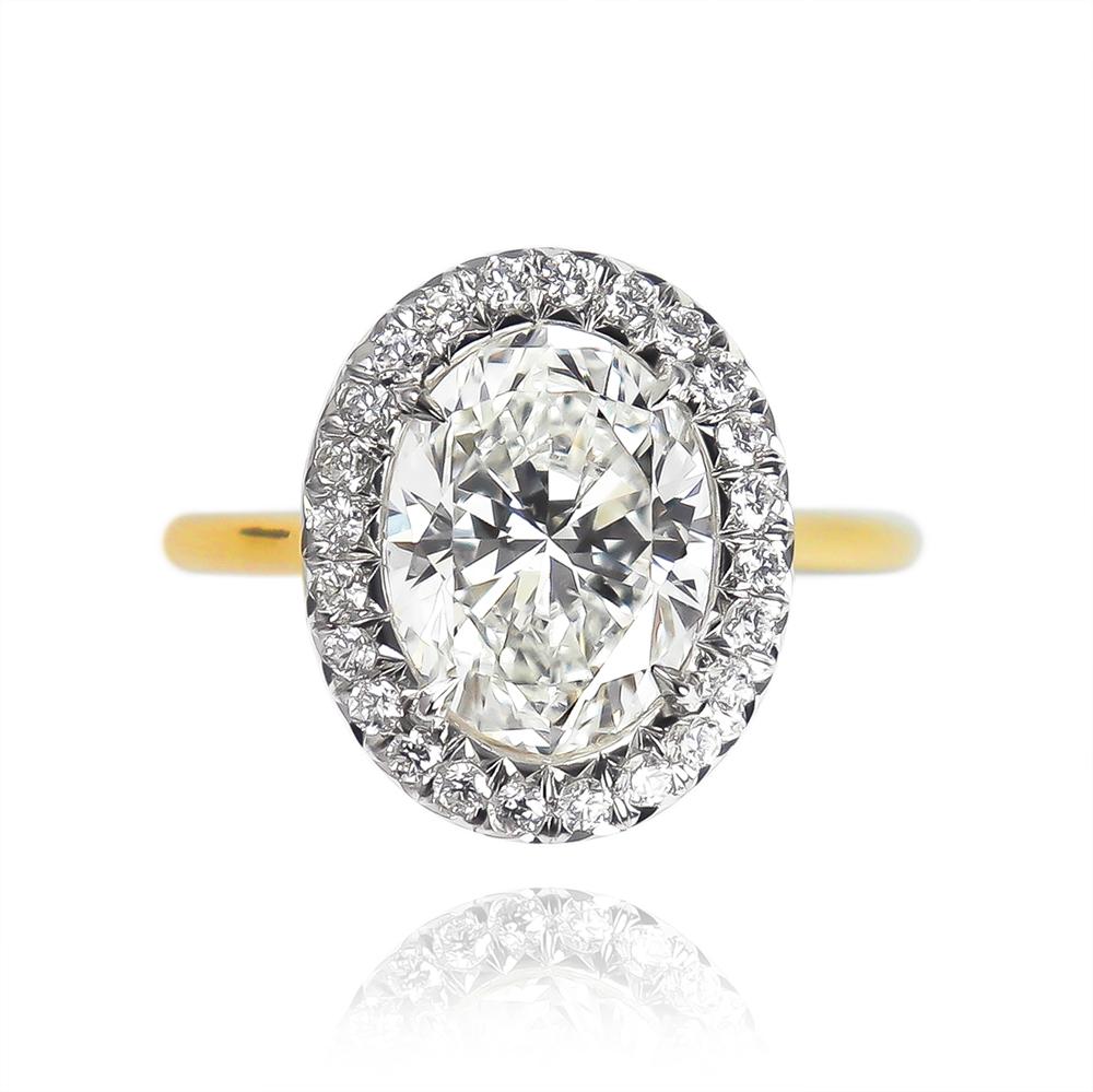 This scintillating beauty features a 2.00 ct oval diamond of F color and SI1 clarity... Set in a platinum and 18K yellow gold mounting with pavé details = 0.28 ctw, this ring is beyond breathtaking from every angle. 

Purchase includes complimentary