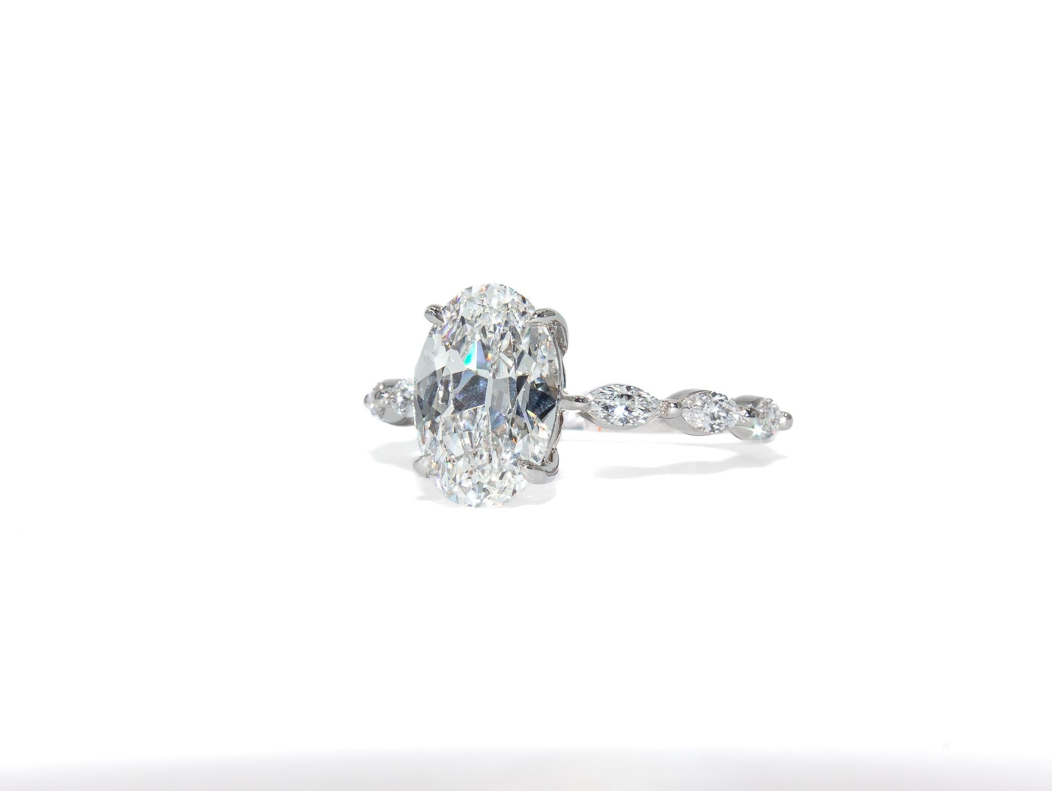 Cette élégante bague J. Birnbach en or blanc 18 carats met en valeur un époustouflant diamant ovale de 2,02 carats, certifié par le GIA avec une couleur E et une pureté VS1. La couleur et la clarté exceptionnelles de la pierre centrale en font une