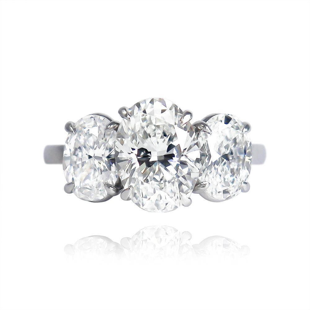 This classic and enchanting ring features a 2.03 carat oval diamond of G color and VS2 clarity... Set in a traditional, three-stone ring with beautifully matched, oval side stones = 1.60 ctw, this huge look is guaranteed to take her breath away!