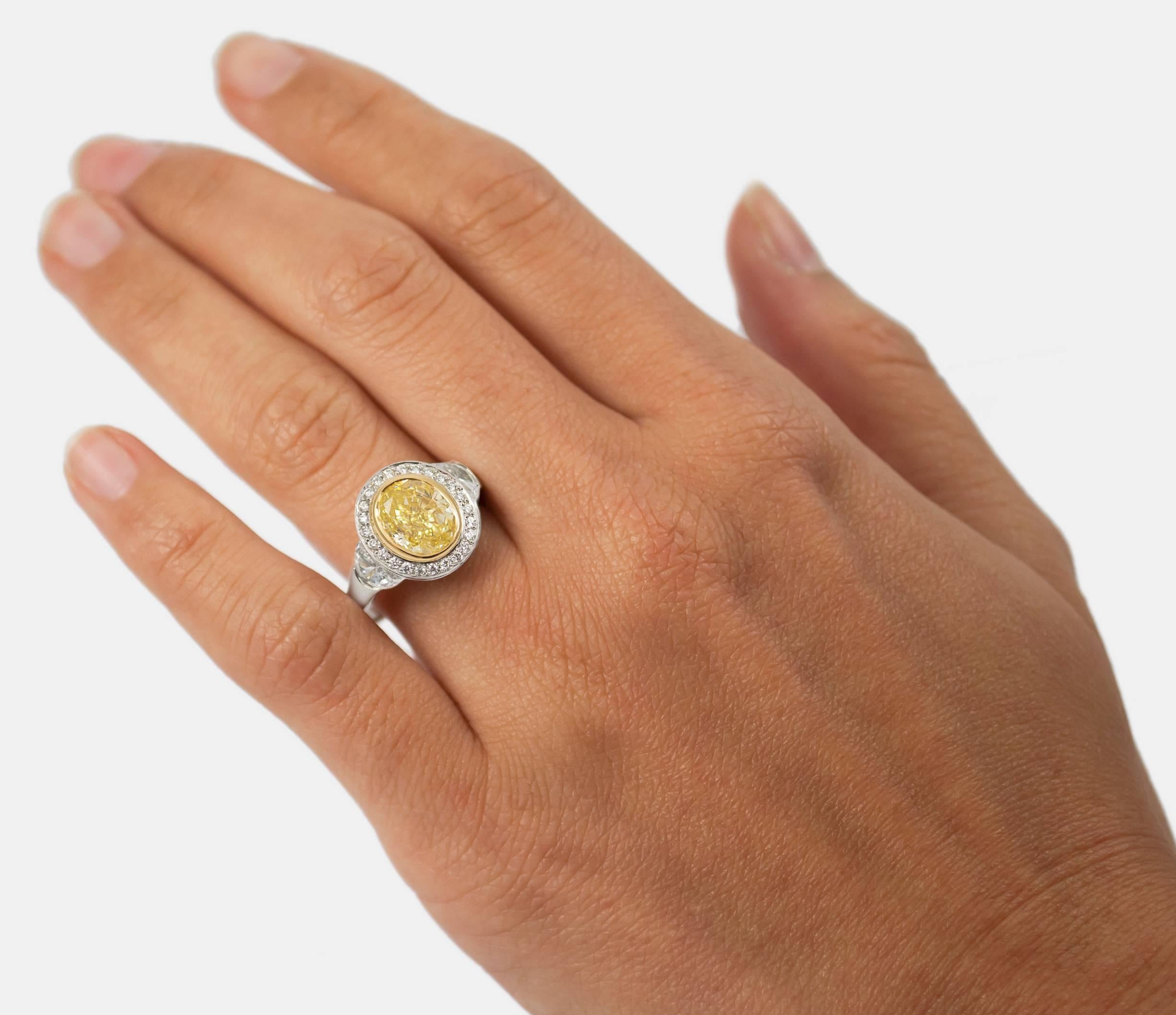 This breathtaking piece features a 2.07 carat Fancy Yellow Oval Diamond of SI1 clarity, flanked by 2 half moons weighing 0.65 ctw. Truly timeless, the mounting is made of platinum with an 18k yellow gold setting to showcase the natural beauty of